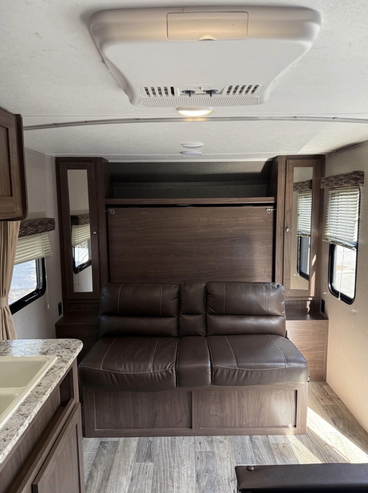 Explore this rv rental's versatile interior with a comfy sofa, folding Murphy bed, & compact kitchen area.. Keystone RV Hideout 2018