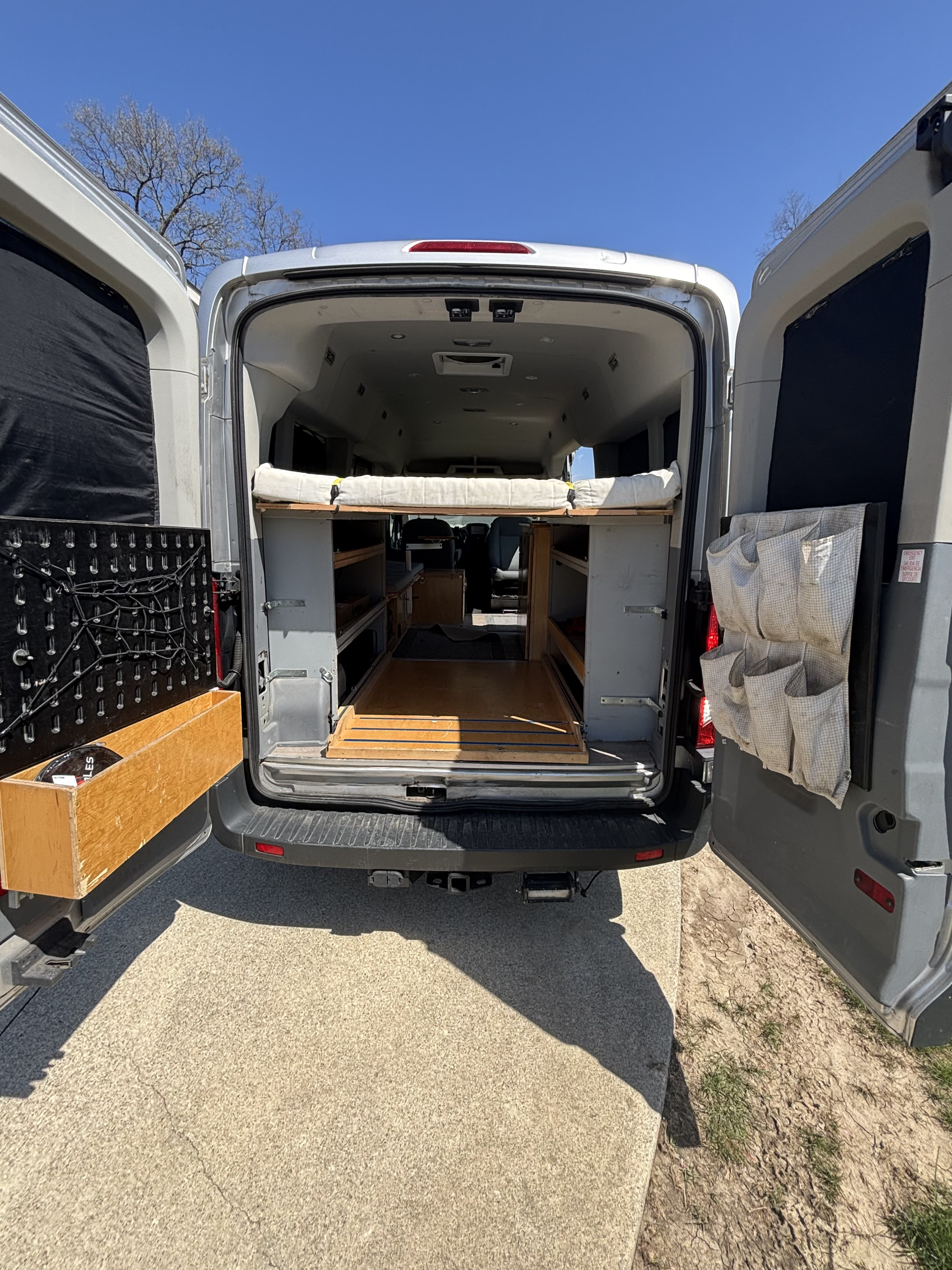 Customized camper van interior for your next RV rental adventure. Features a bed, storage, and organizers.. Ford Transit 2015