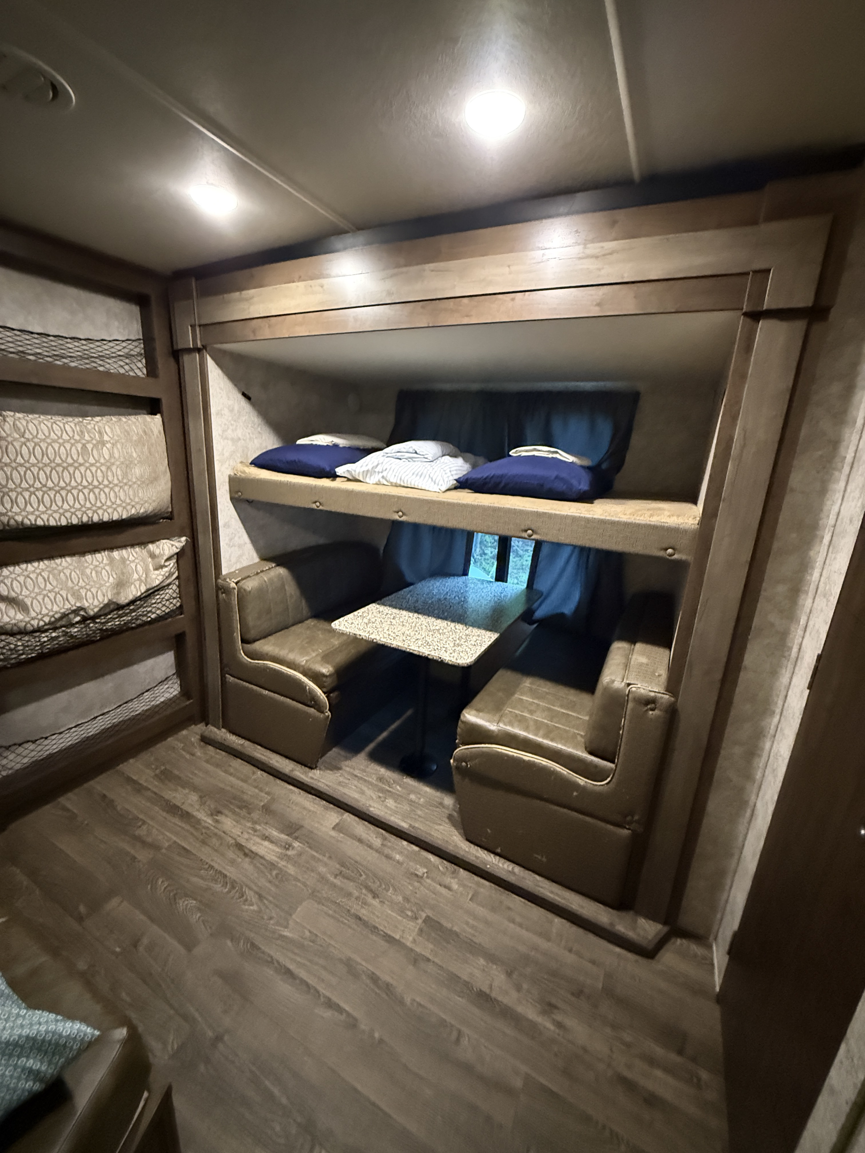 RV rental interior featuring bunk beds, a dinette with seating and table. A cozy and compact travel trailer living space.. Highland Ridge RV Mesa Ridge 2019
