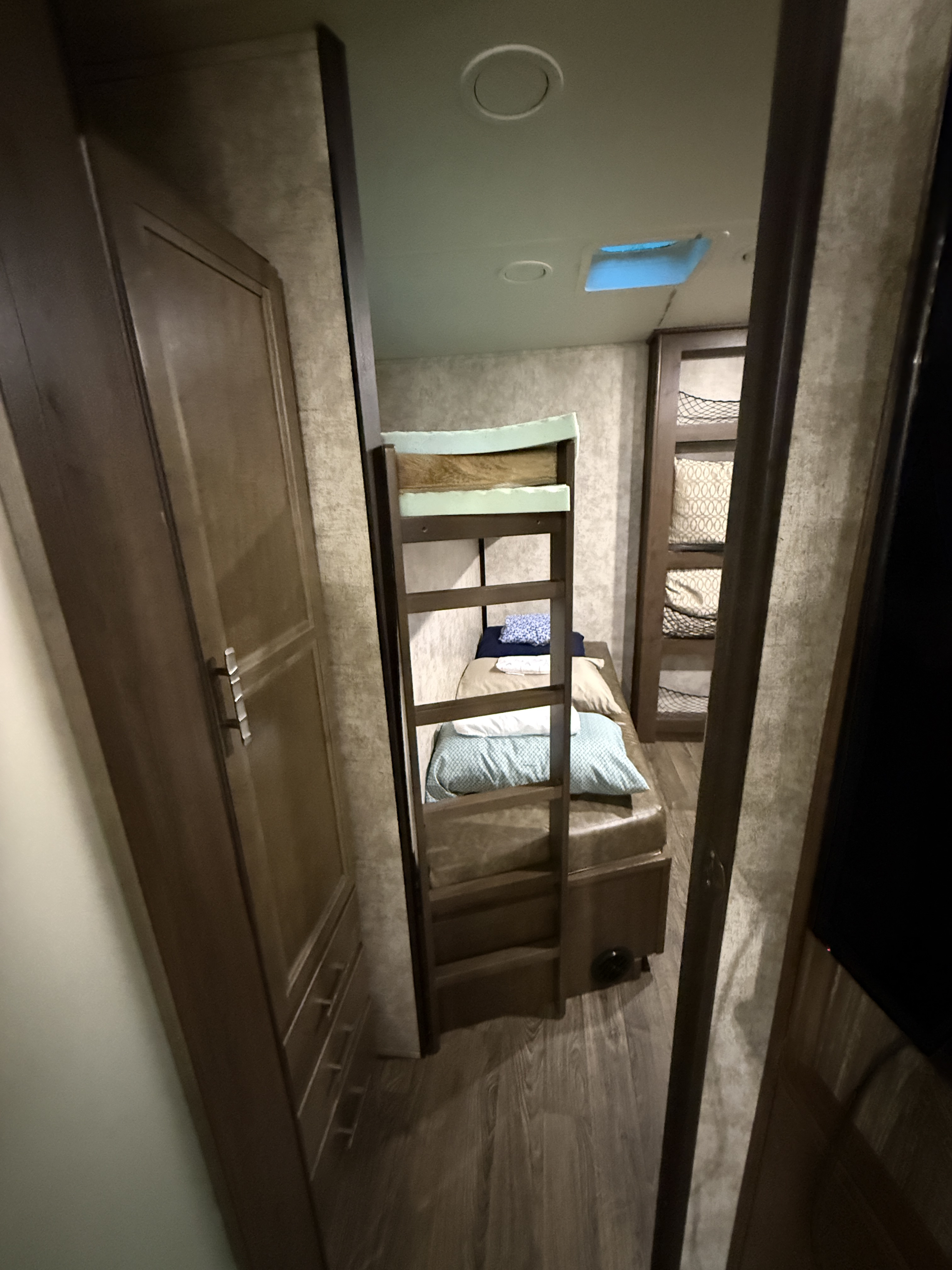 Cozy RV rental bunk room: features comfy bunk beds with ladder, adjacent wardrobe, and netted storage, ideal for families.. Highland Ridge RV Mesa Ridge 2019