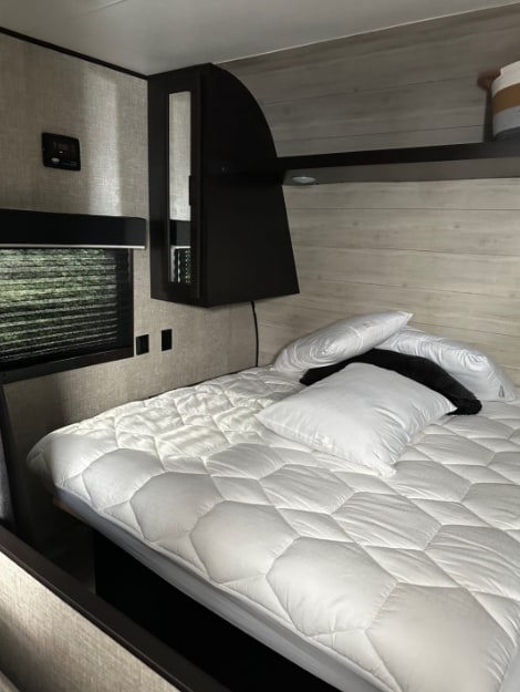Relax in this RV rental bedroom. It features a comfortable quilted bed, window, and stylish cabinetry, ideal for your travels.. Jayco Jay Flight 2022