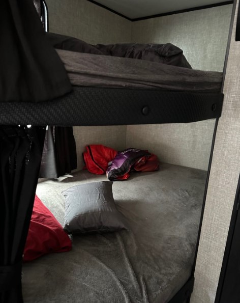 RV rental interior: two cozy gray bunk beds with privacy curtains and storage space visible.. Jayco Jay Flight 2022
