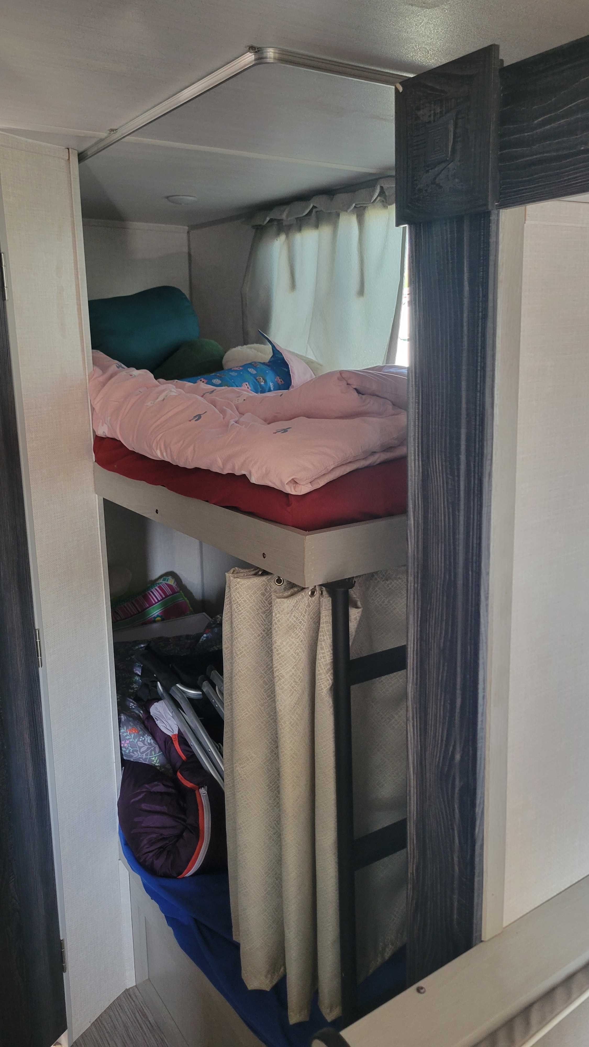 RV rental interior features comfy bunk beds with colorful bedding and useful storage, ideal for compact travel.. Forest River Ibex 2021