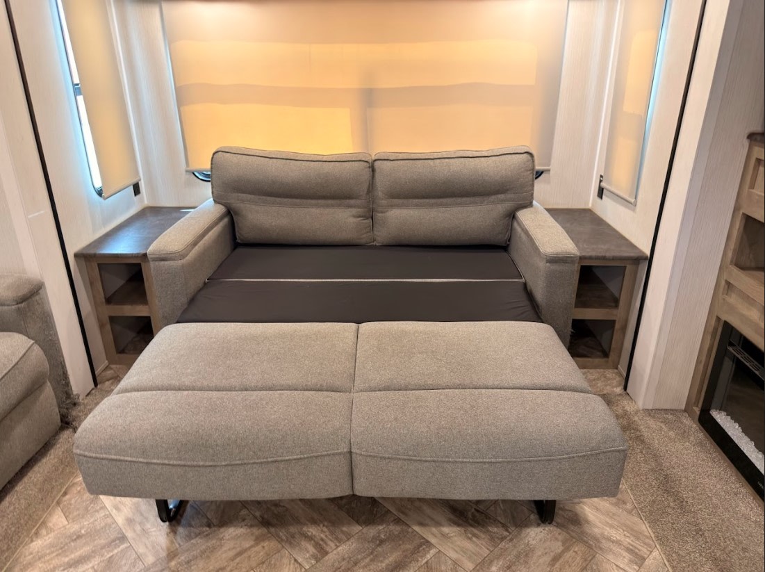 RV rental: Comfy convertible sofa bed with built-in storage tables for ultimate convenience.. Forest River Puma 2023