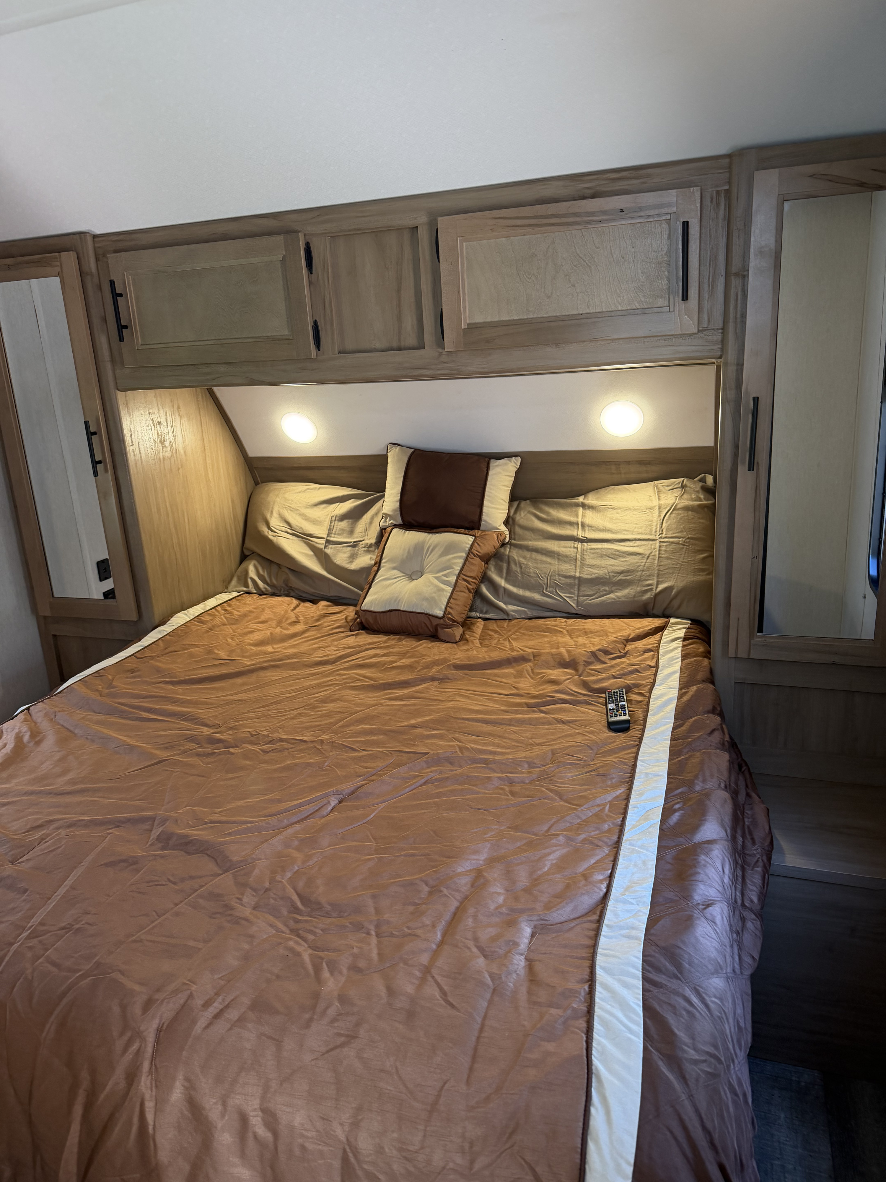 Enjoy a comfortable RV rental bedroom featuring a cozy bed, overhead cabinets, and reading lights.. Forest River Cherokee Grey Wolf 2023