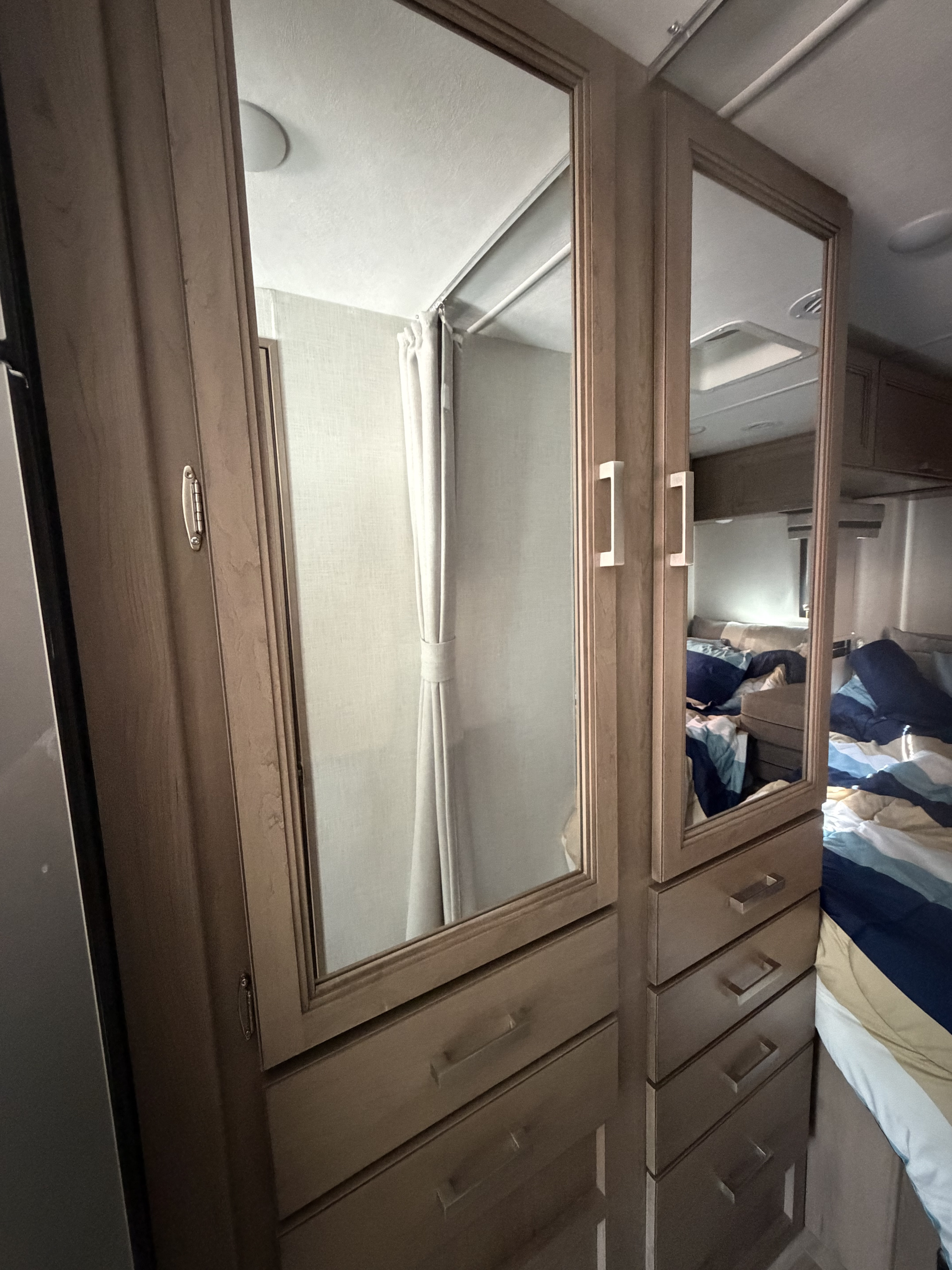 RV rental interior: Mirrored closets reflecting a bed and a shower, showcasing compact yet functional living space.. Thor Vegas 2026