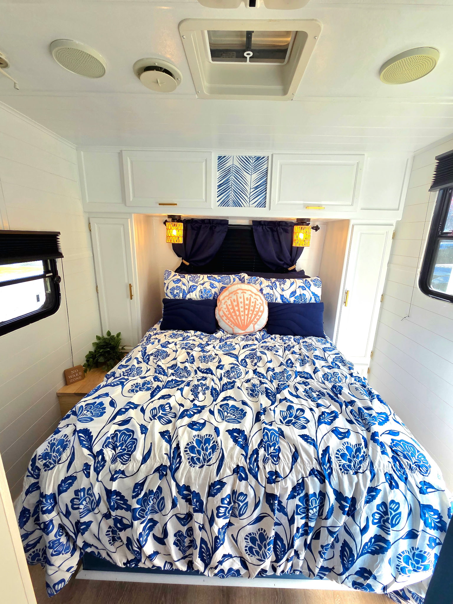 This bright RV rental bedroom features a comfy bed with blue floral bedding, shiplap walls, and modern decor.. Sunline Solaris 2002