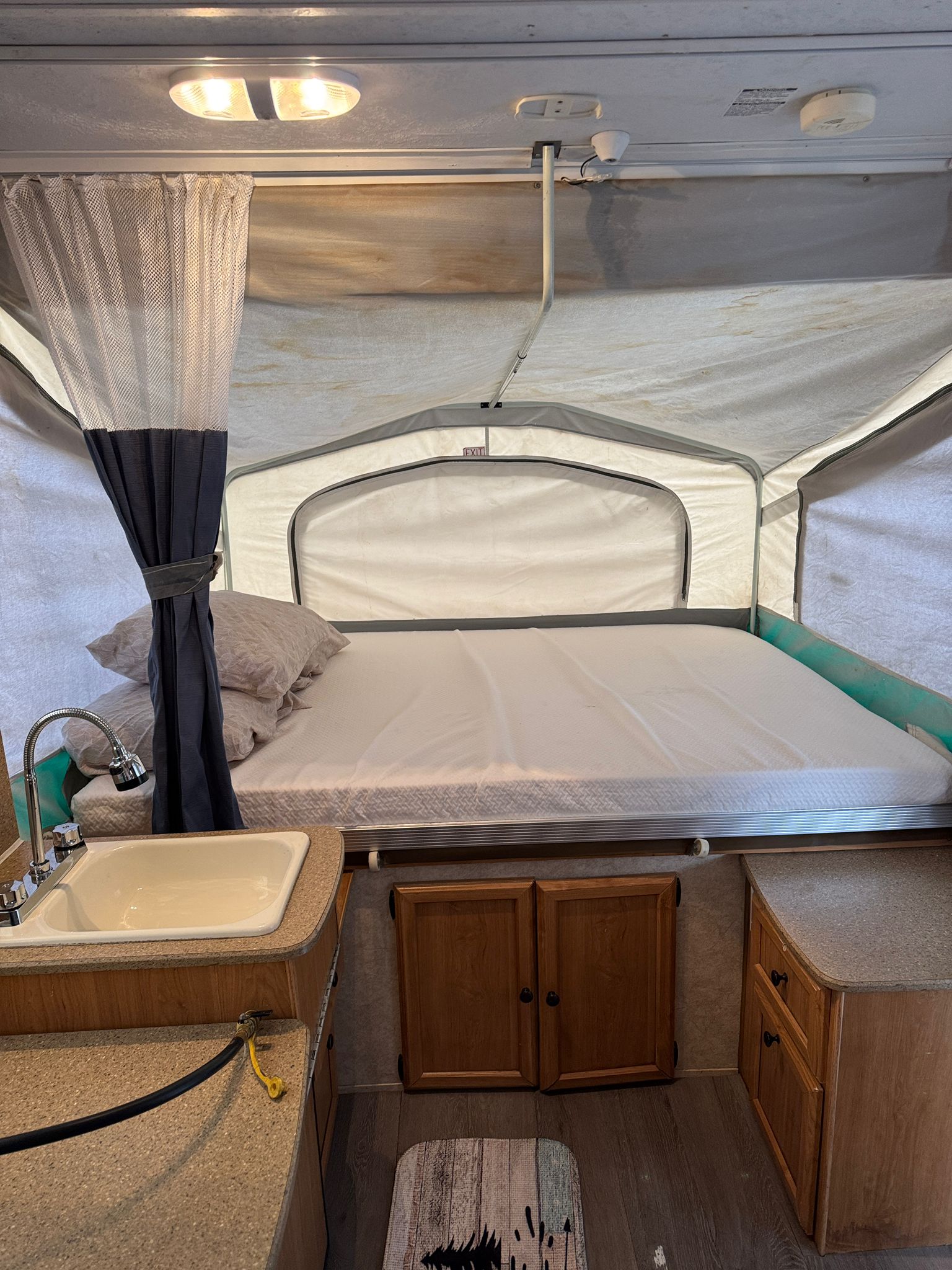 Inside this pop-up RV rental: a comfy bed, full sink, counter, and cabinets. Ready for your camping adventure!. Forest River Palomino Y-Series 2010