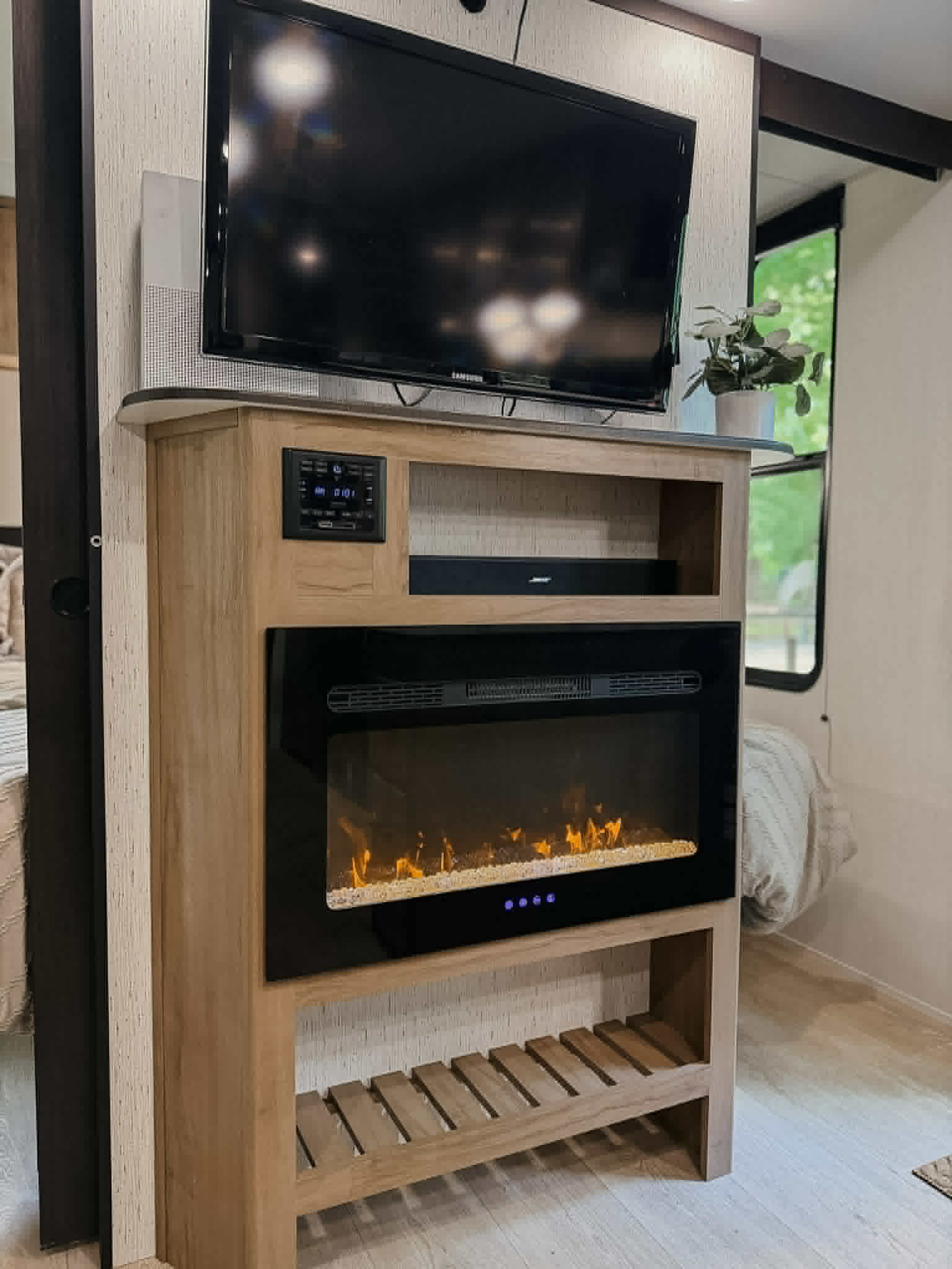 Cozy RV rental interior featuring a wood entertainment center with a TV, soundbar, and glowing electric fireplace.. Forest River Cherokee Grey Wolf 2025