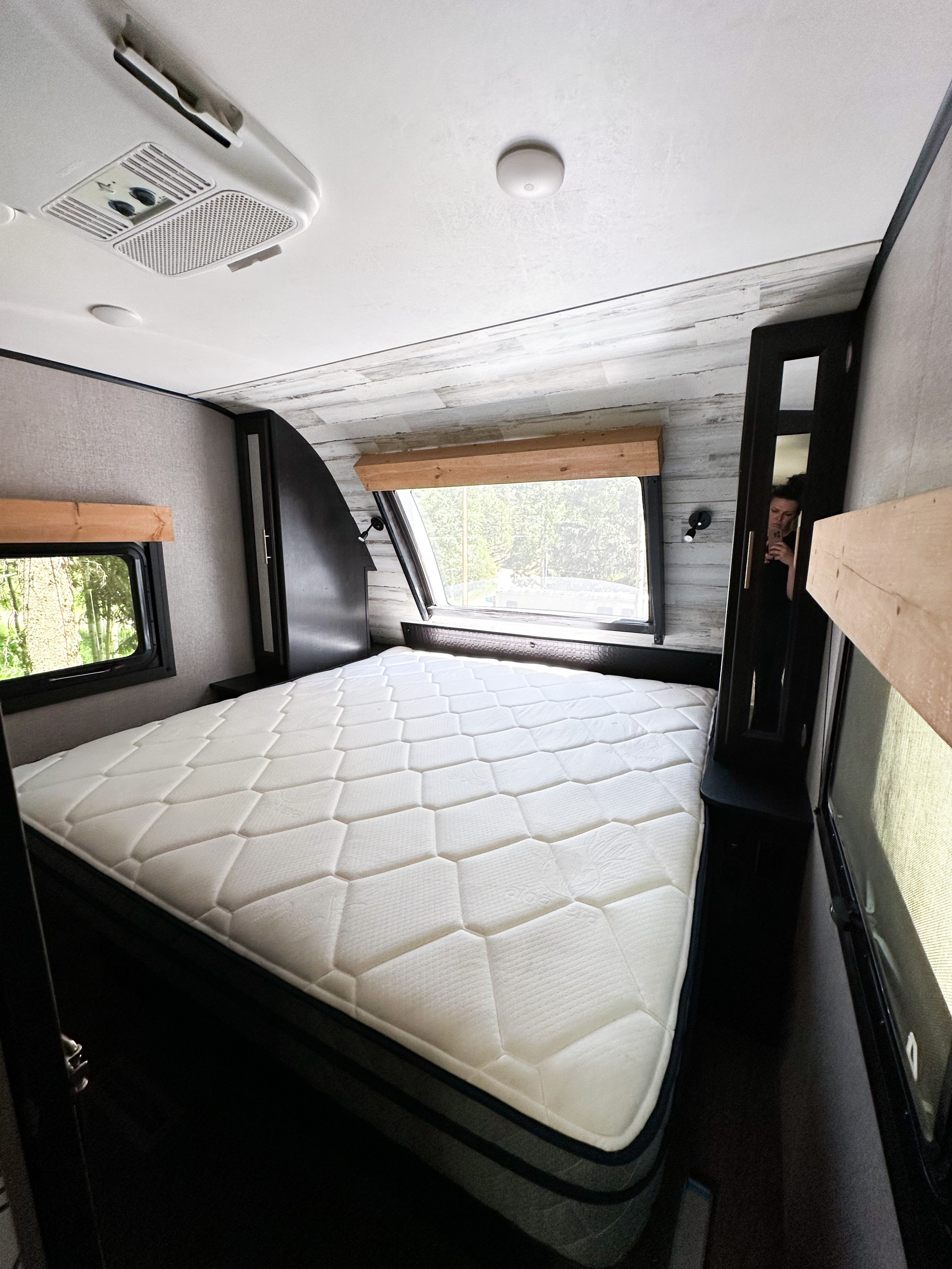 RV rental bedroom interior: soft mattress, windows with nature views, and ceiling AC. Ready for travel comfort.. Jayco White Hawk 2021