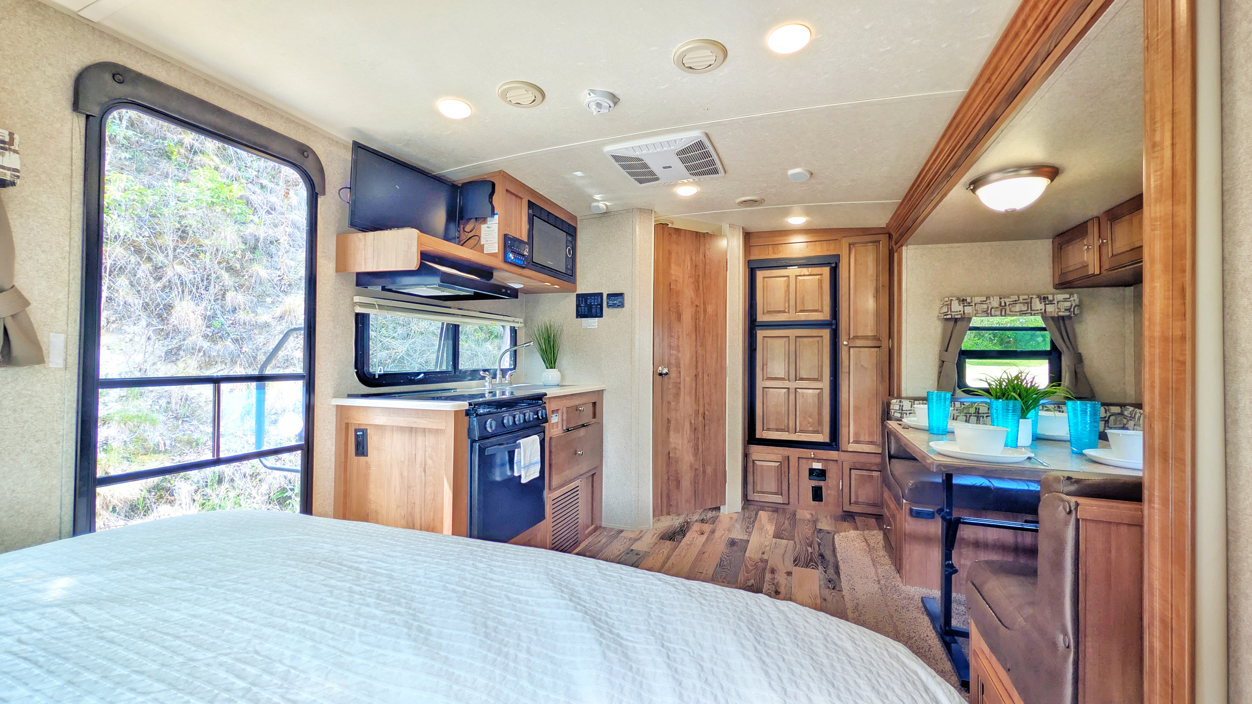 RV rental interior: A bright, functional space with a large bed, full kitchen, dining booth, and refrigerator.. Forest River Rockwood Mini Lite 2018