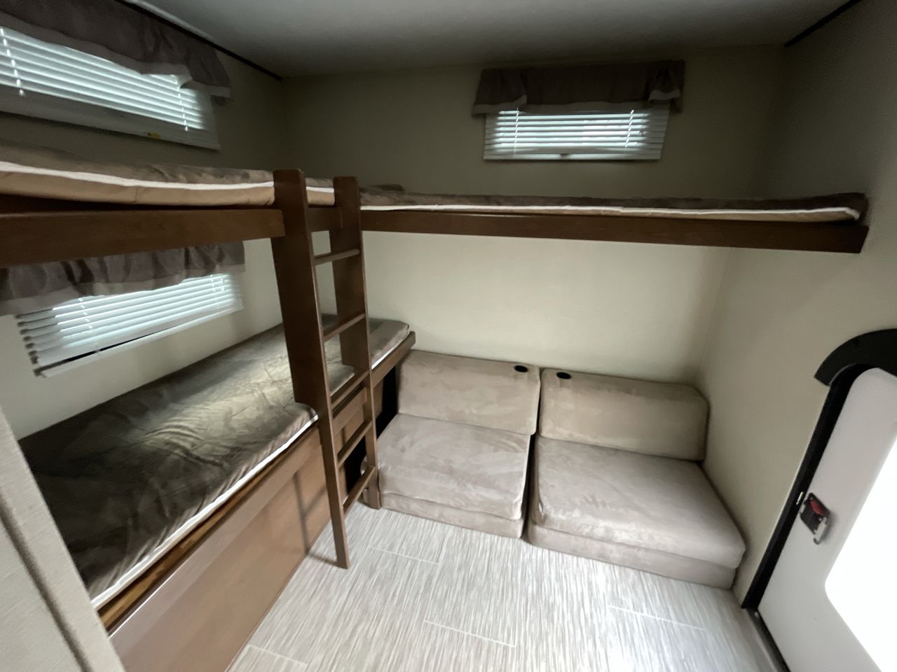 This RV rental offers a compact bunk bed area with a ladder, two sleeping berths, & comfy beige seating.. Forest River Tracer 2018