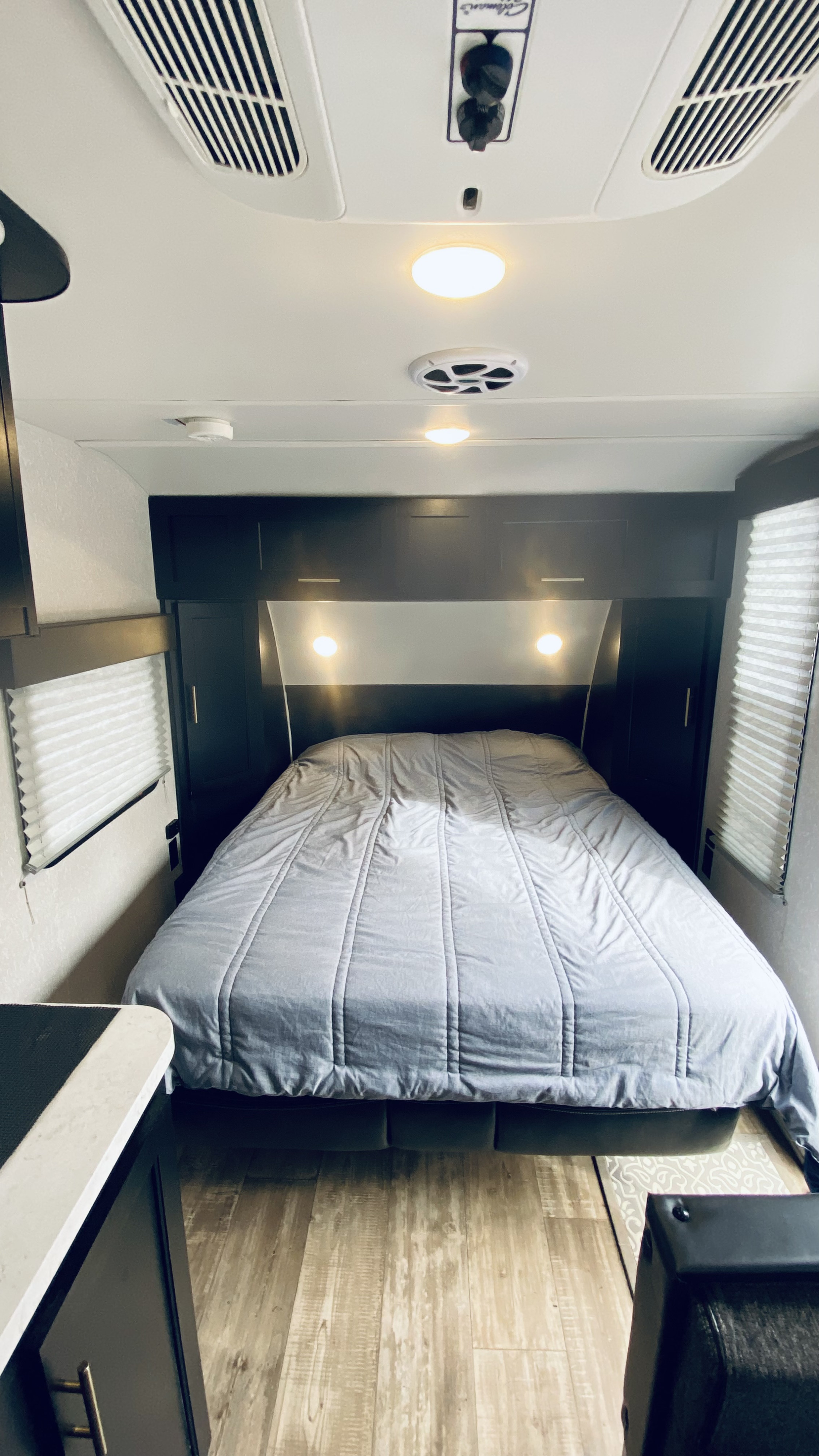 This cozy RV rental bedroom offers a comfortable queen bed, overhead storage, and wood-look flooring. Ideal for your next trip!. Forest River Cherokee Wolf Pup 2022