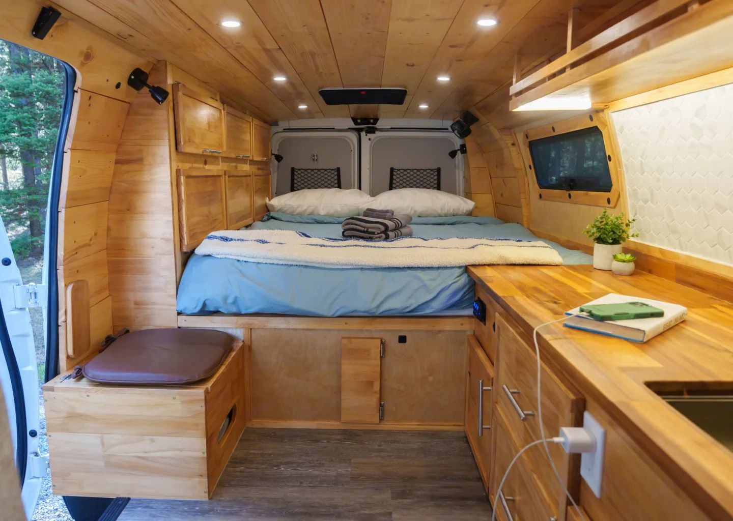 This RV rental offers a cozy wood-paneled interior with a comfy bed, kitchenette, charging station, and smart storage.. Ford E250 EXT 2011