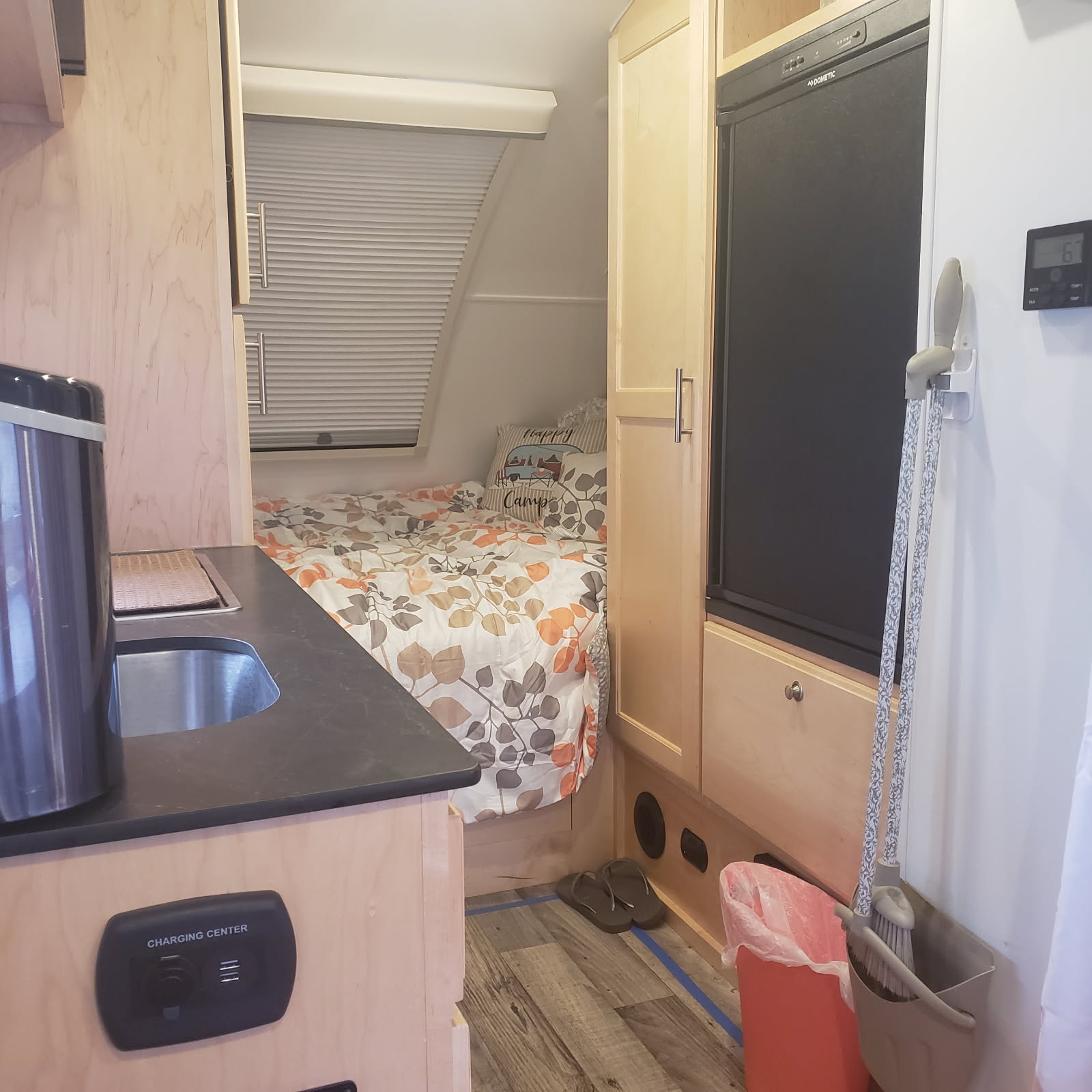 An rv rental's compact interior showing a comfortable bed, kitchenette, fridge, & charging station.. Little Guy Little Guy Trailer 2021