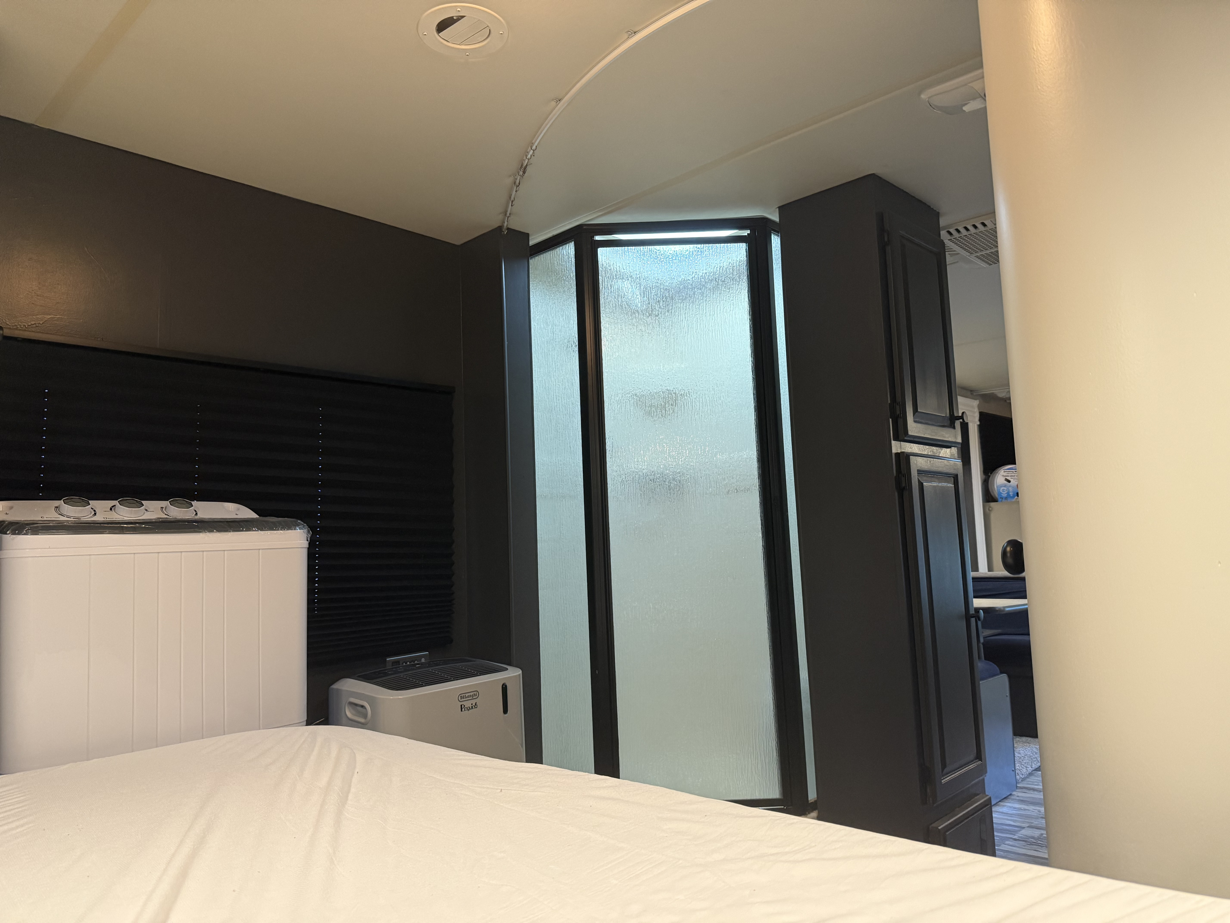RV rental interior: bedroom with compact washer, dehumidifier, and shower, offering home comforts on the road.. Thor Freedom Elite 2012