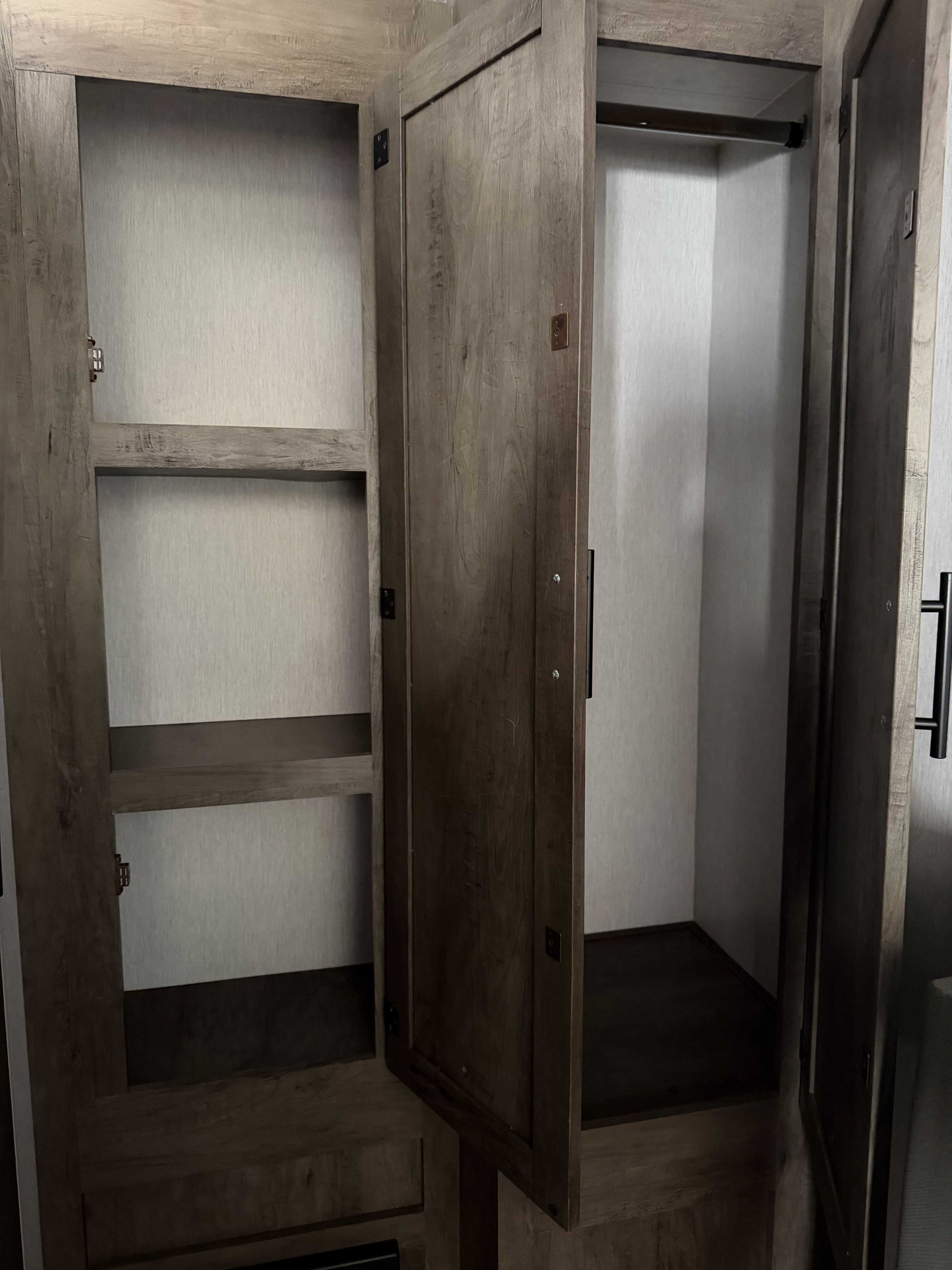 Spacious empty wooden closet in an RV rental, featuring shelves on one side and a hanging rod on the other for ample storage.. Forest River Salem Select 2021