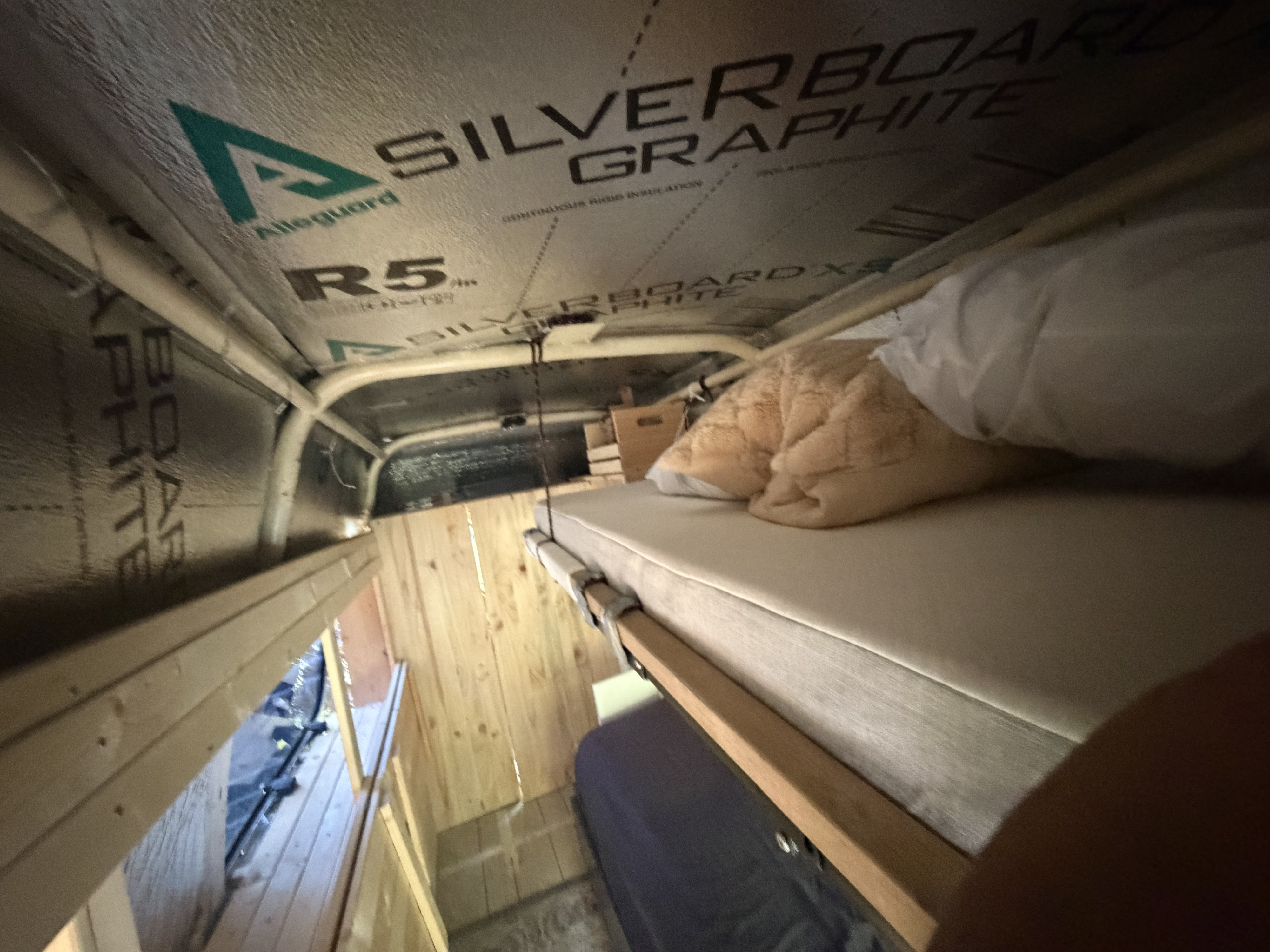 Upward view of an RV rental campervan interior, showing a top bunk bed, lower bed, and insulated ceiling.. Ford Econoline 150 1992
