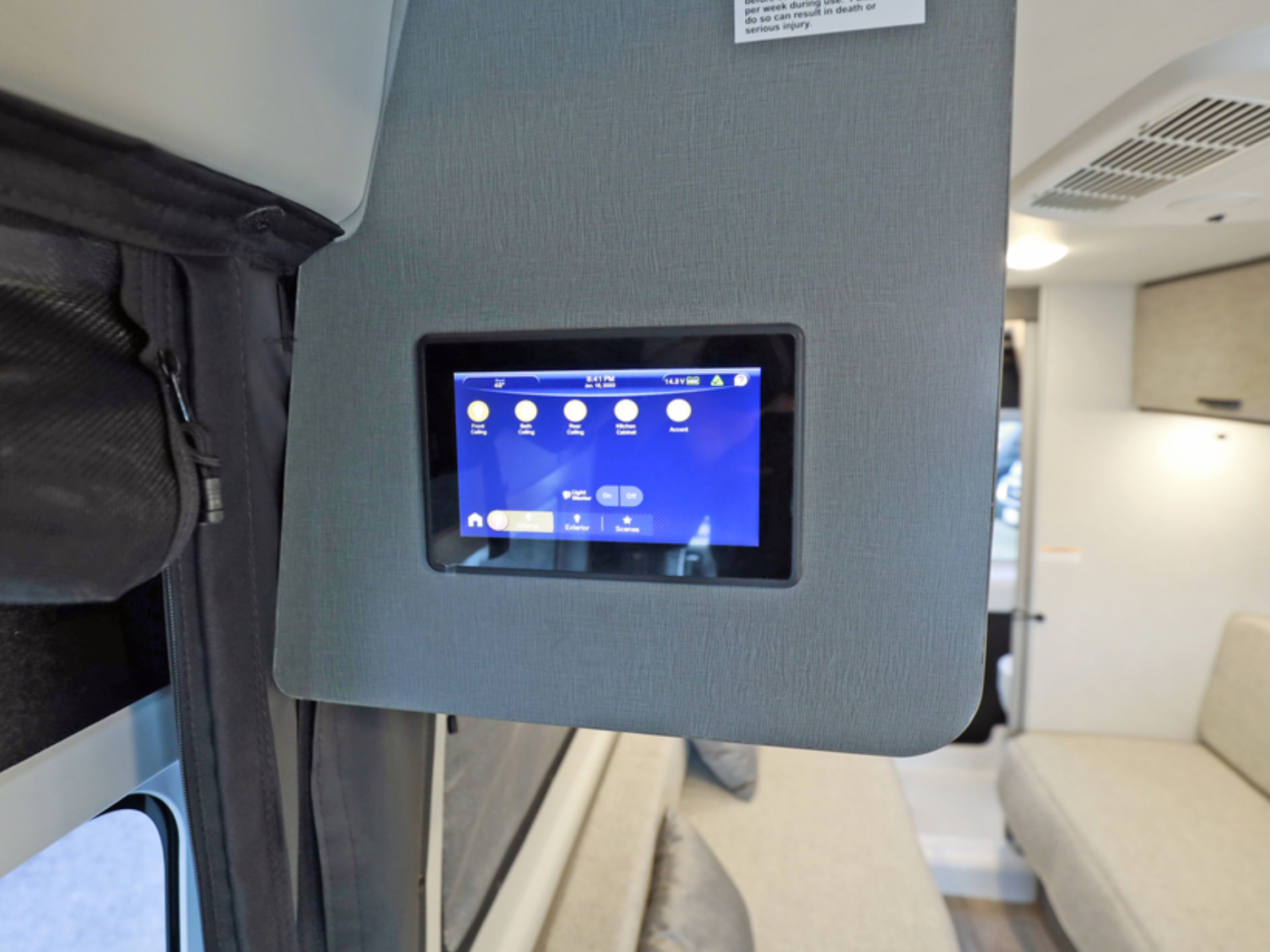 RV rental control panel with a touchscreen display showing interior lighting options and vehicle stats like voltage.. Thor Motor Coach tellaro 2027