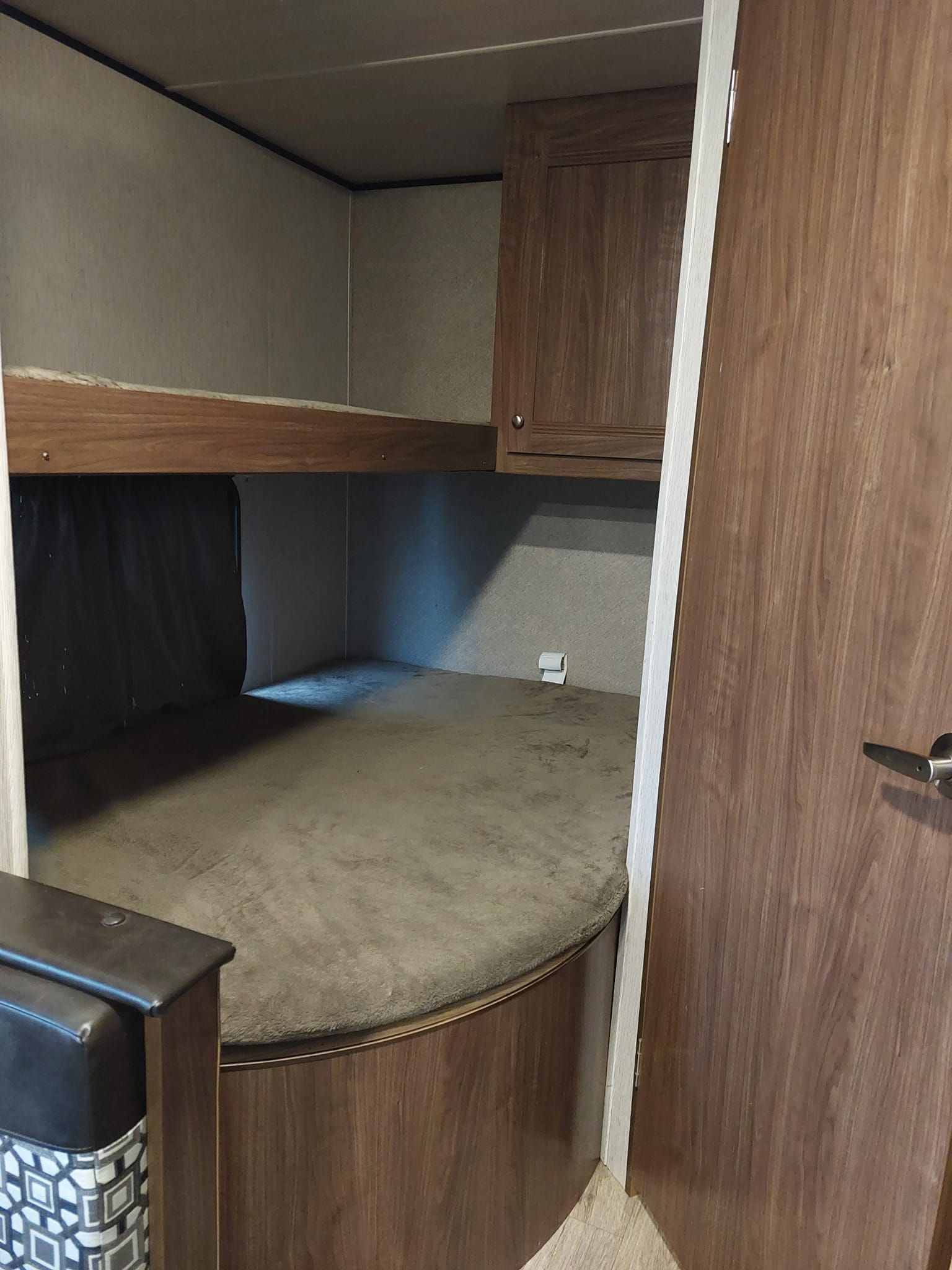 RV rental bunk beds: A cozy, compact sleeping area with wooden frames and gray mattresses, perfect for family travel.. Heartland RVs Prowler Lynx 2018