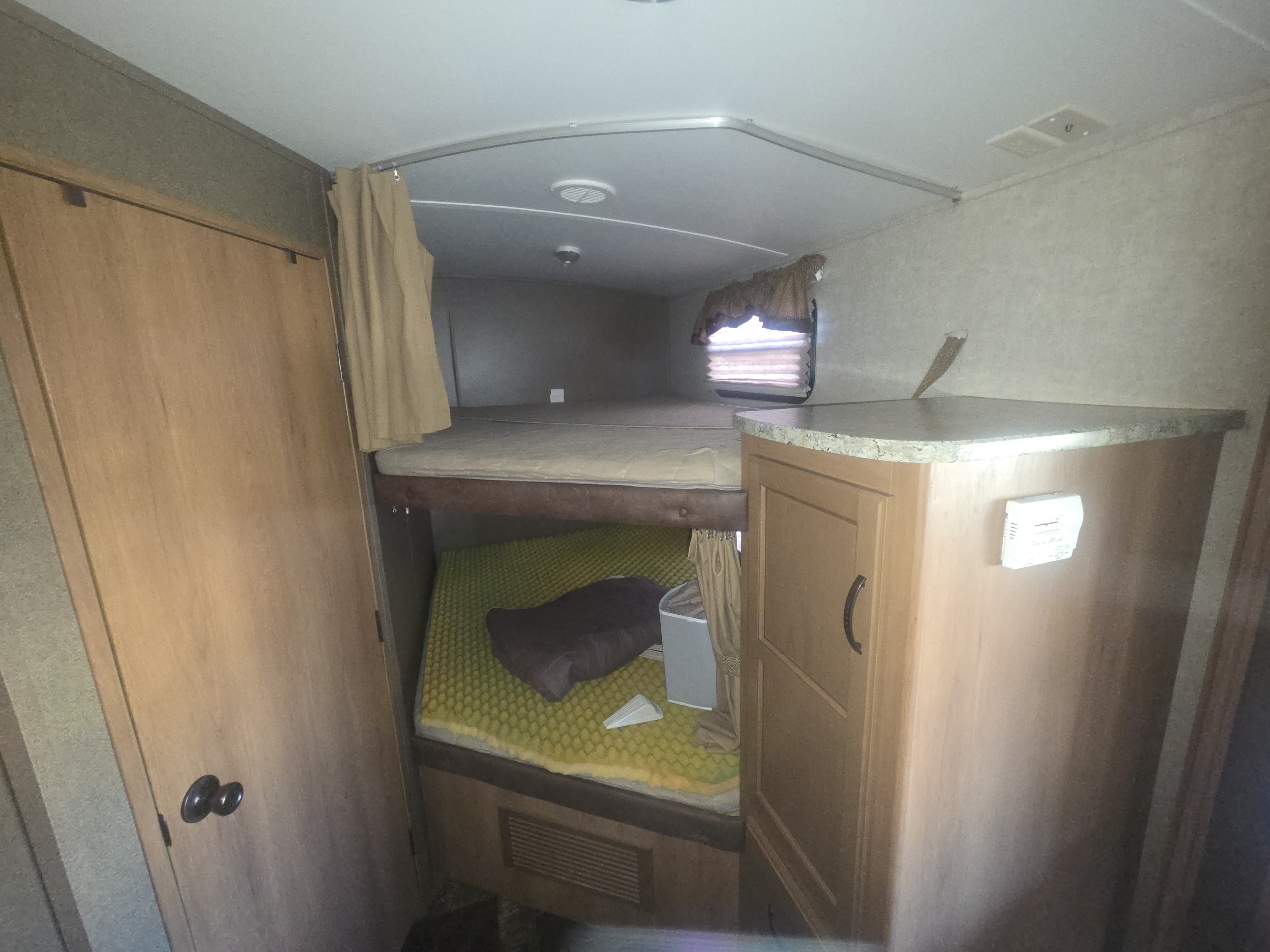 This rv rental features comfortable bunk beds, a corner cabinet with a countertop, and a wall thermostat, ideal for family travel.. Keystone RV Outback Terrain 2013