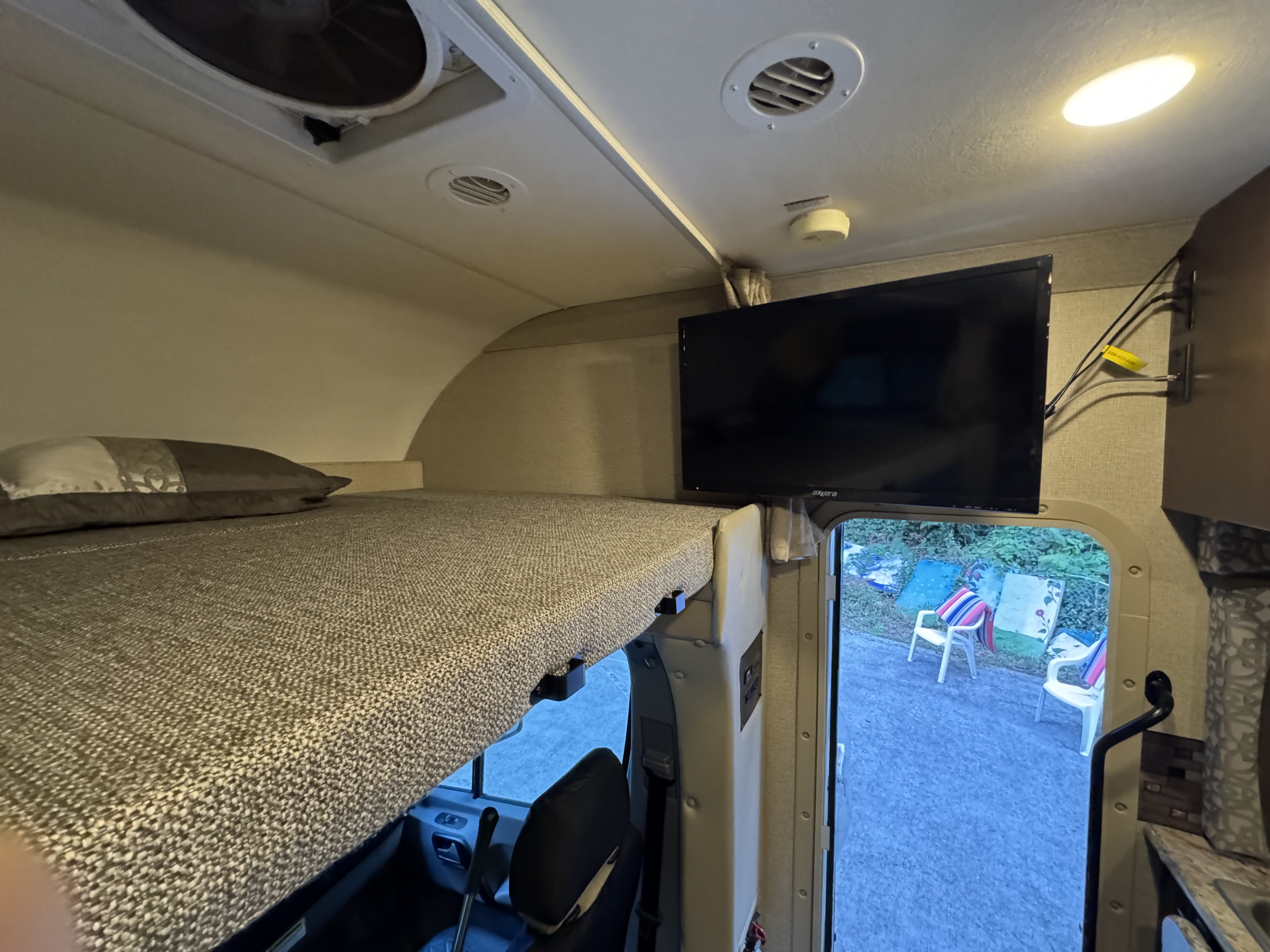 Cozy RV rental cab-over bunk bed with TV and ceiling fan. Features a convenient outdoor view from the interior.. Thor Chateau Sprinter 2018
