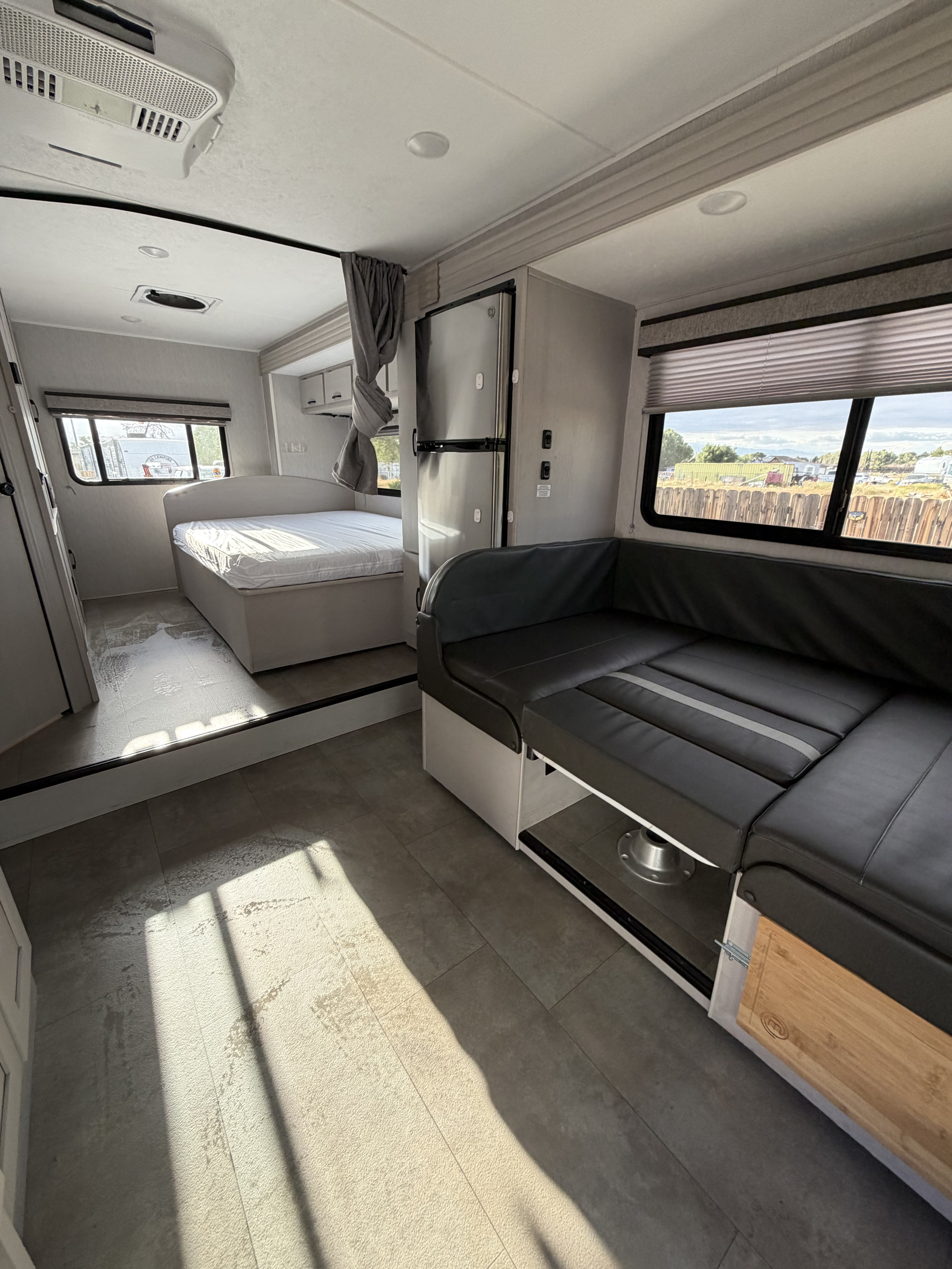 Modern RV rental interior with bedroom, kitchen, and dinette. Bright, compact living space for travel.. Forest River Coachmen Freelander 2023