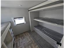 RV rental bunkhouse: clean interior with two bunks on the right, single bunk & storage on left, small window.. Forest River Shasta 2023