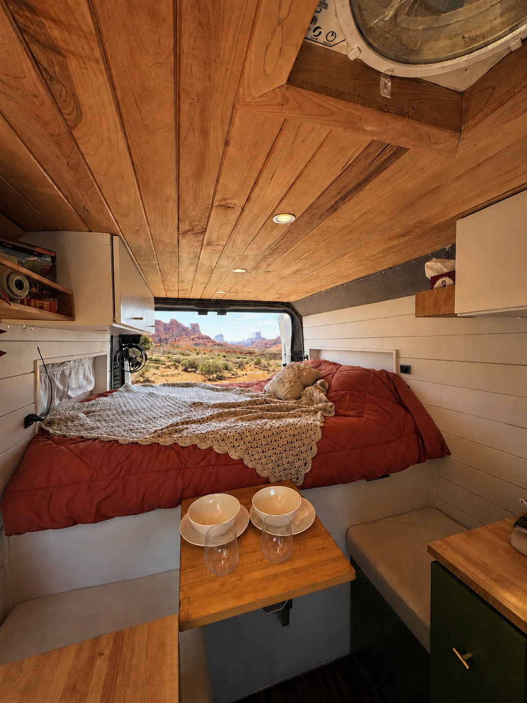 Cozy RV rental interior with a bed, dining area, and stunning desert view. Perfect for adventure travel and van life.. Dodge Ram Promaster 2020
