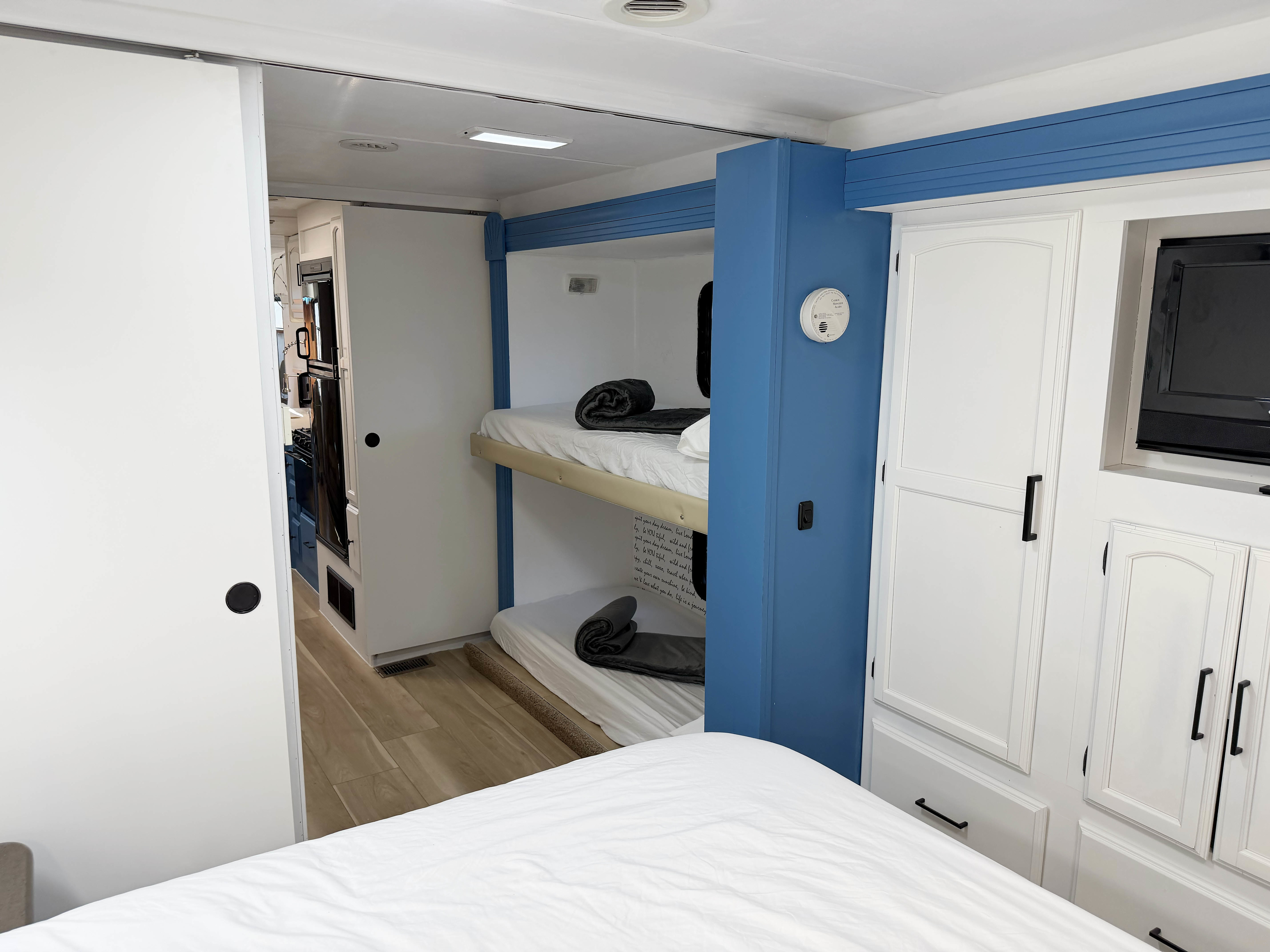 Compact RV rental features blue & white interior, bunk beds, kitchen glimpse, & cabinets. Ideal for family travel.. Forest River Coachmen 2012