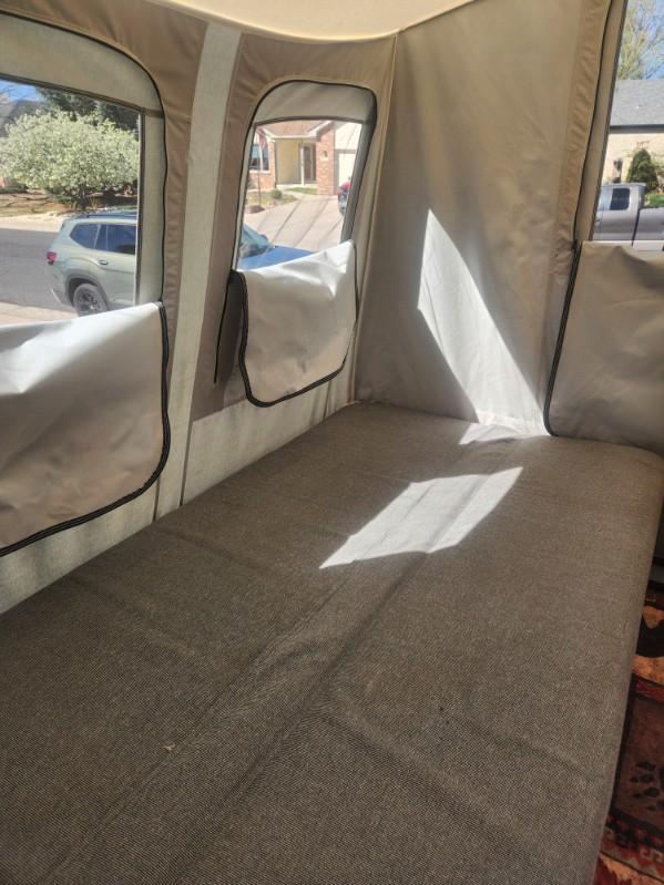 RV rental interior: Pop-up camper's comfy bed, windows showing outside, with sunlight creating patterns.. Jumping Jack 6 X 8 2007