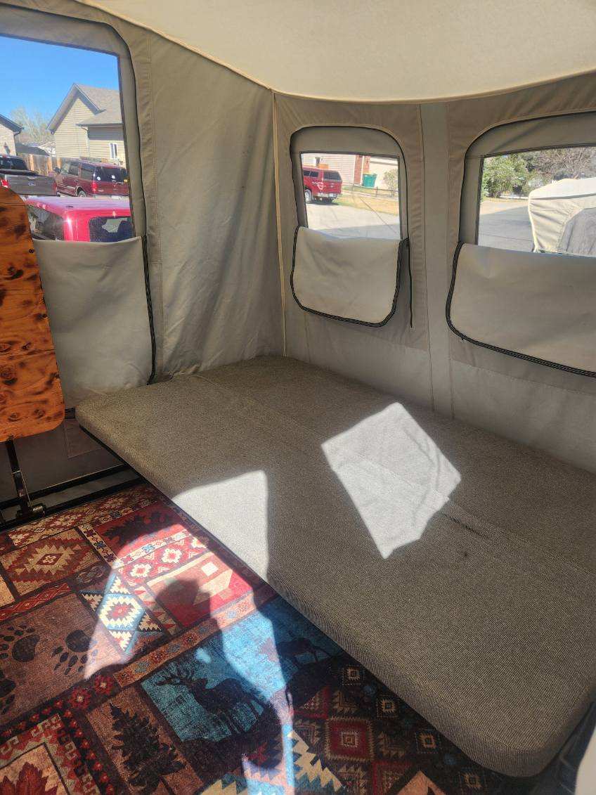 Inside this rv rental, find a comfy bed with a colorful patterned rug. Sunlight streams through windows, offering views outside.. Jumping Jack 6 X 8 2007
