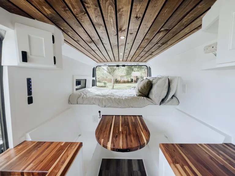 Experience van life in this RV rental! Bright interior features a wooden ceiling, cozy bed, and functional compact kitchen.. Dodge B Van 2021