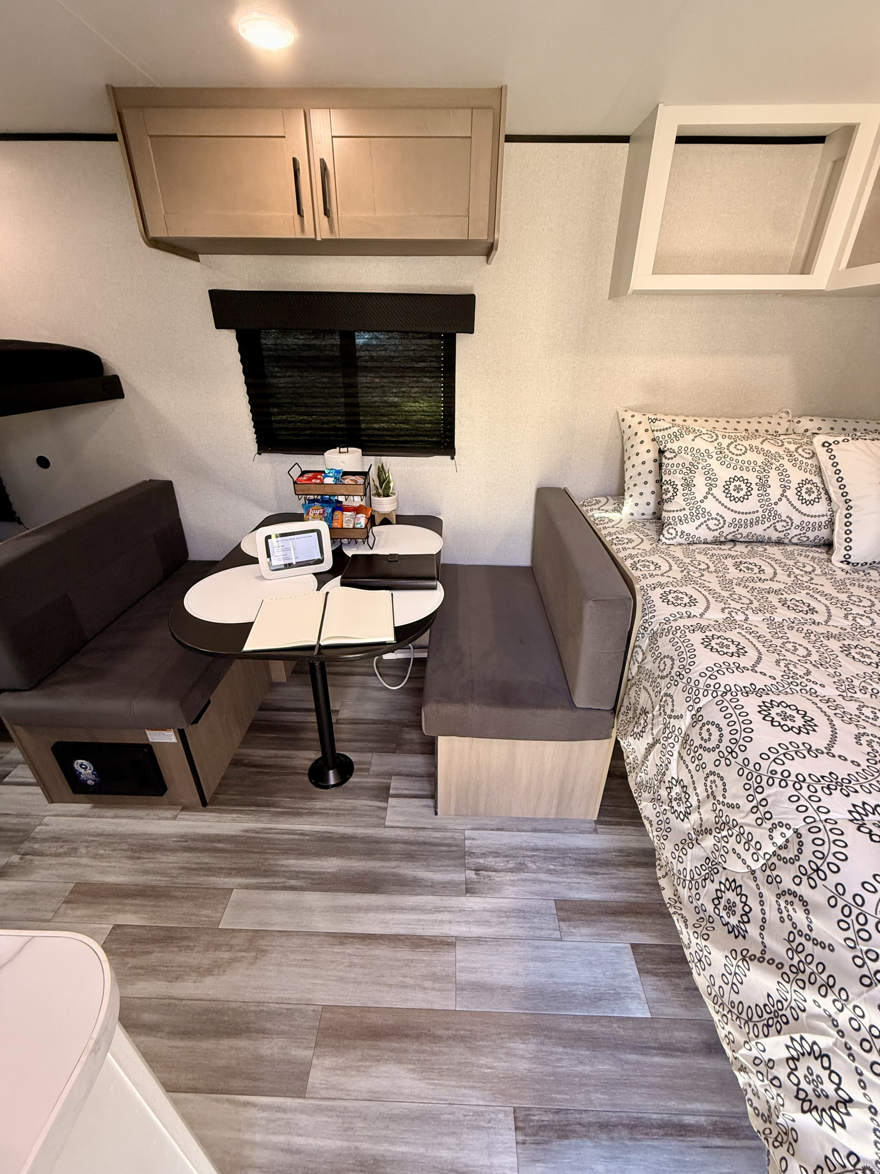 Cozy RV rental interior showcasing a dinette with snacks & tablet, comfortable bed, and ample storage, ideal for adventures.. Jayco 170BH 2026