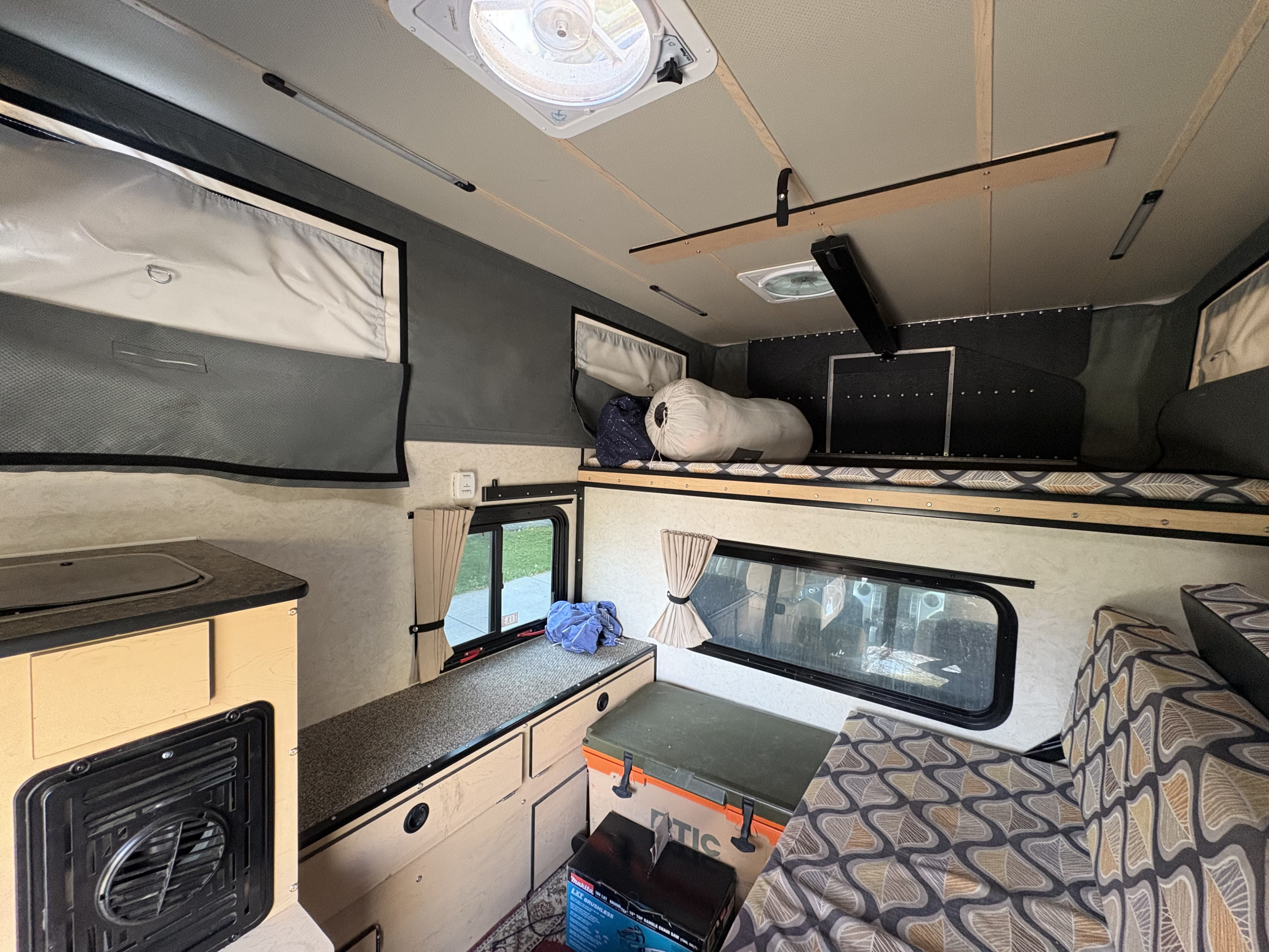 Explore this cozy RV rental interior: kitchenette, sleeping bunk, and comfortable seating for your next adventure.. Four Wheel Campers Hawk 2022