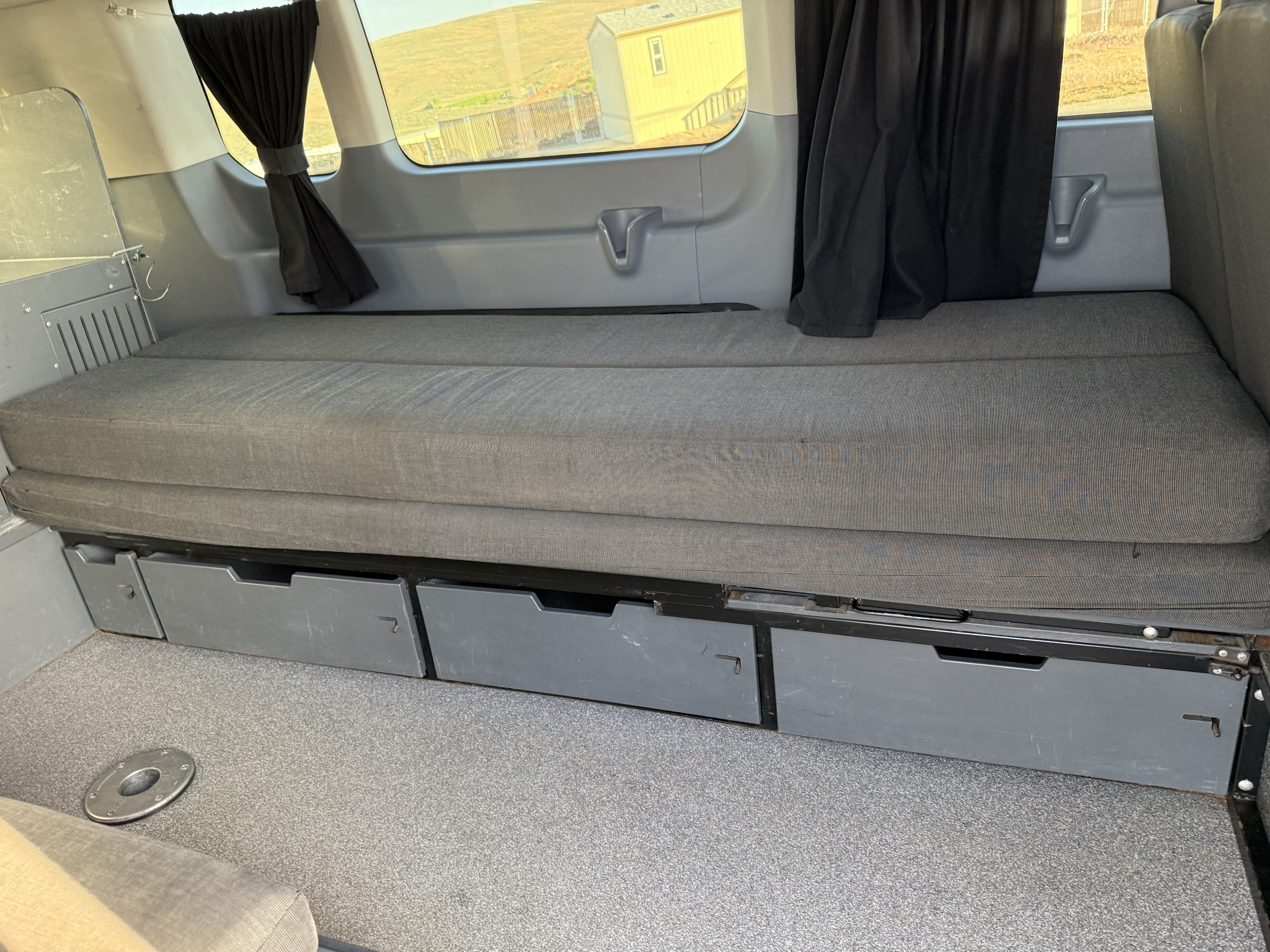 This RV rental offers a cozy, convertible bed with convenient under-bed storage drawers and window curtains for privacy.. Ford Transit 2017