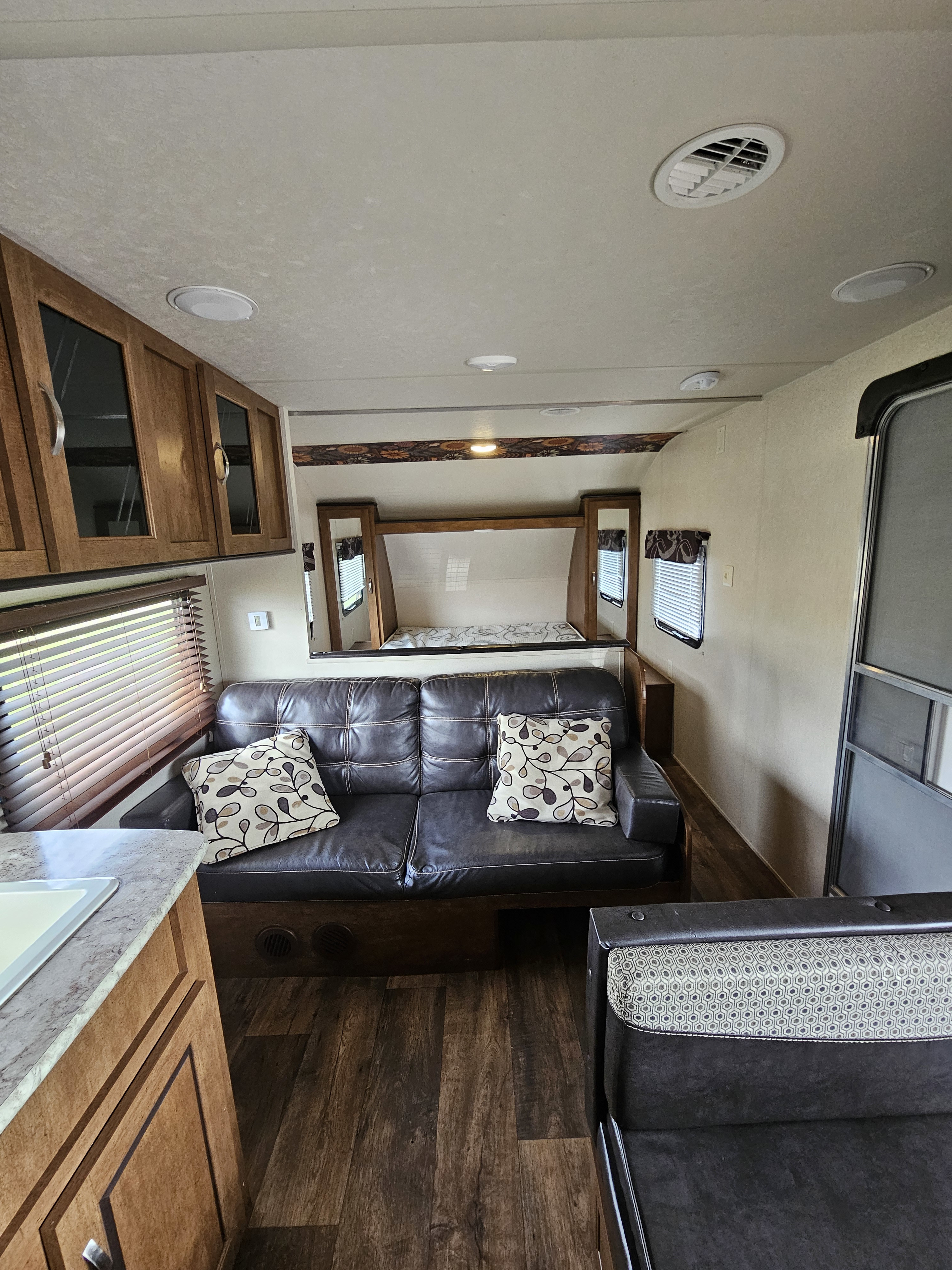 Spacious rv rental interior with a comfy sofa, bunk bed, and kitchen area, perfect for travel.. Forest River Salem Cruise Lite 2017