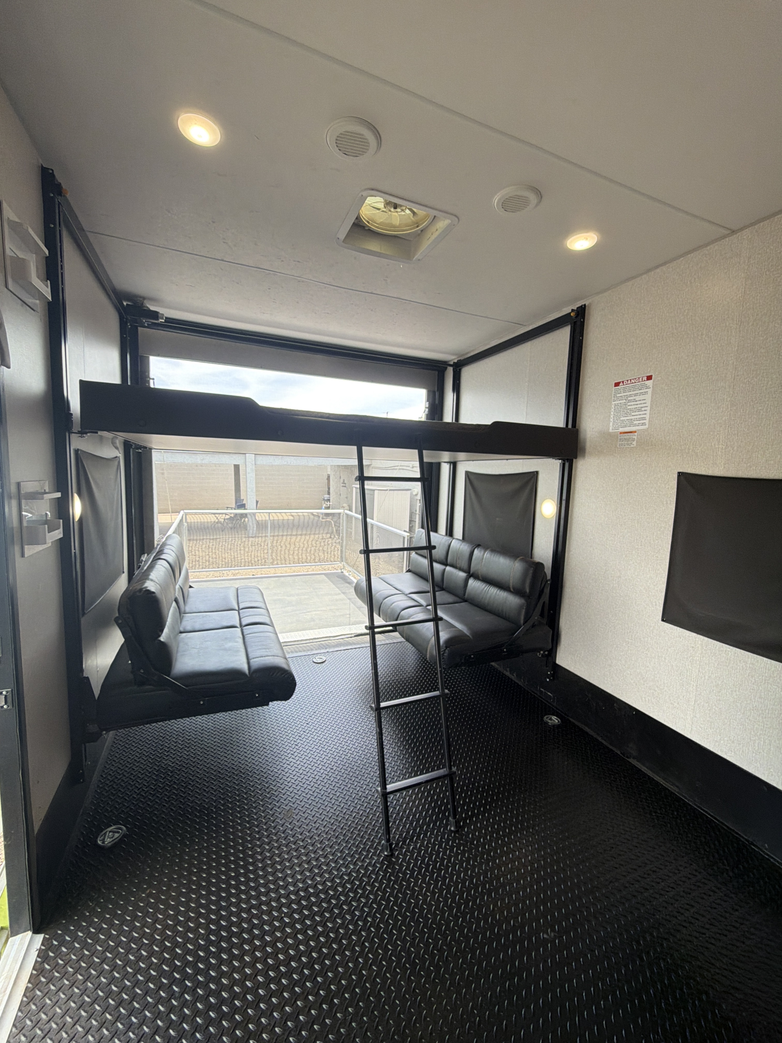 RV rental: Spacious toy hauler interior with convertible sofas, bunk bed, rugged diamond plate floor, and patio view.. KZ 331th13 2021