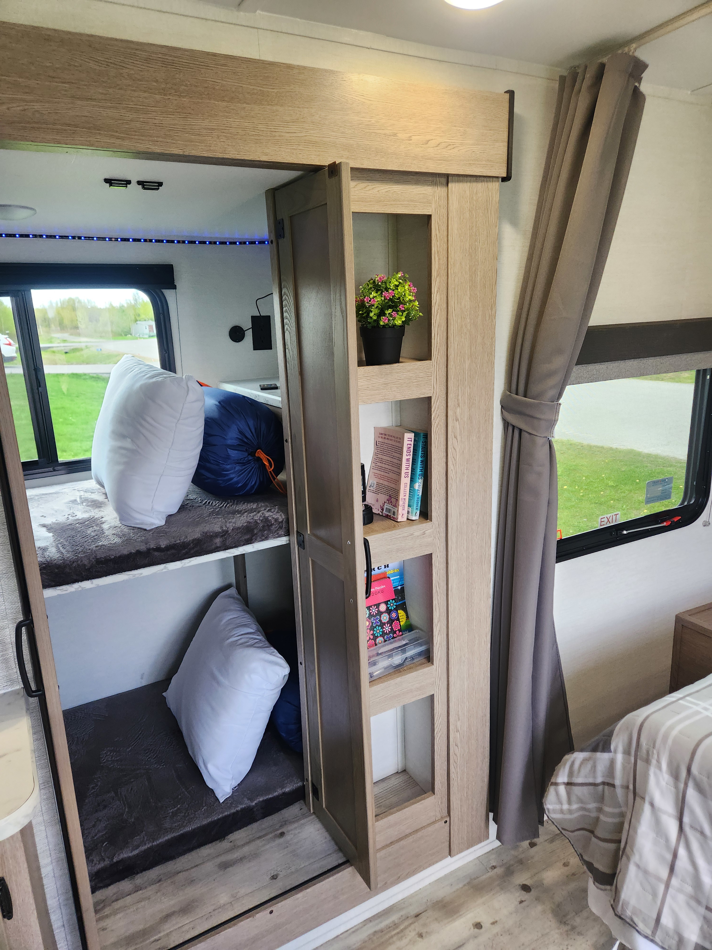 Cozy RV rental interior featuring bunk beds, a reading nook with books, and bright LED lighting, perfect for family adventures.. Gulf stream Grand river 2026