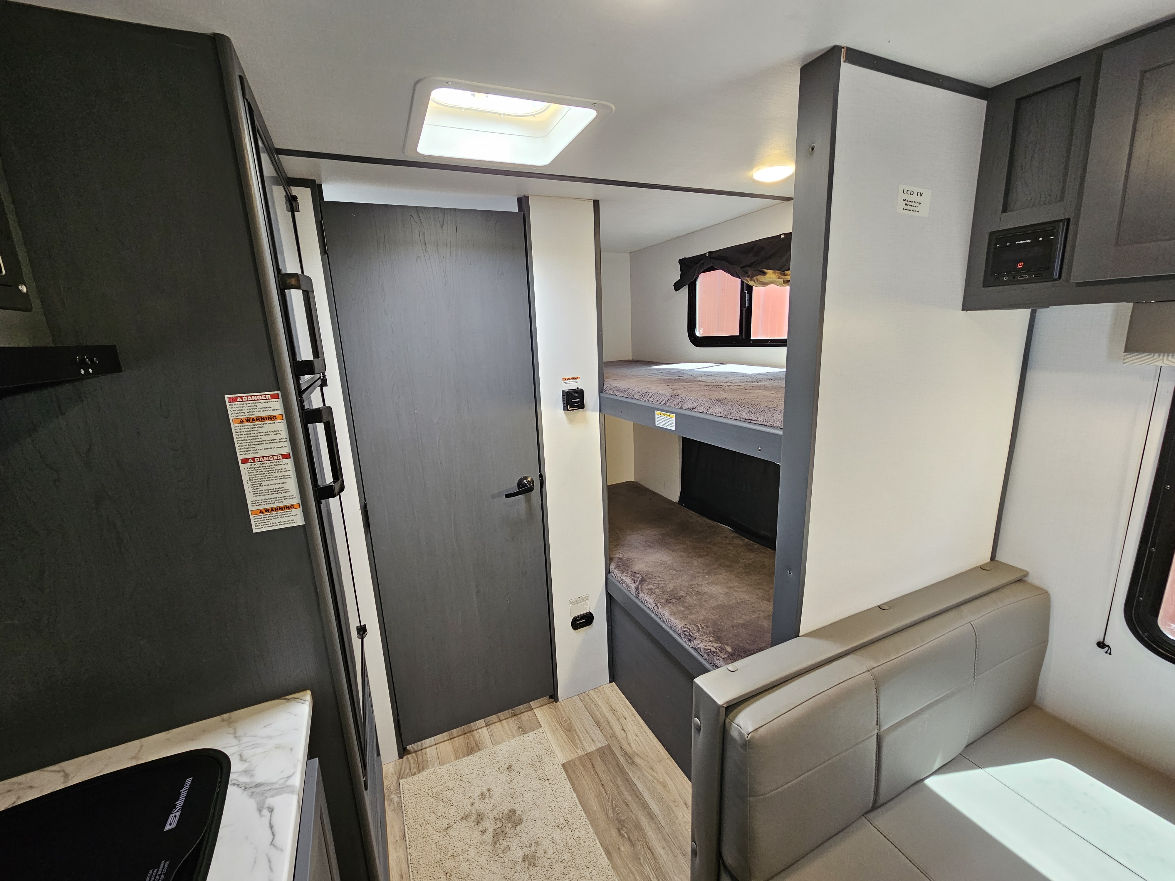 RV rental interior: kitchen with fridge, bunk beds, and dinette. Compact living space for travel adventures.. Keystone RV Bullet Crossfire 2022