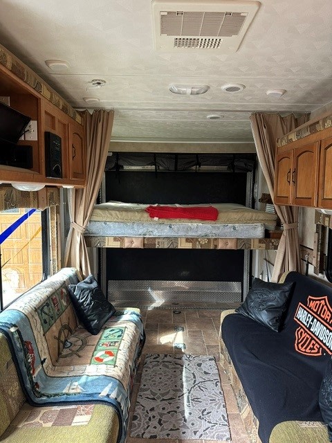 RV rental: Spacious toy hauler interior featuring dual sofas, overhead storage, and a versatile rear bunk bed.. Forest River Puma 2011