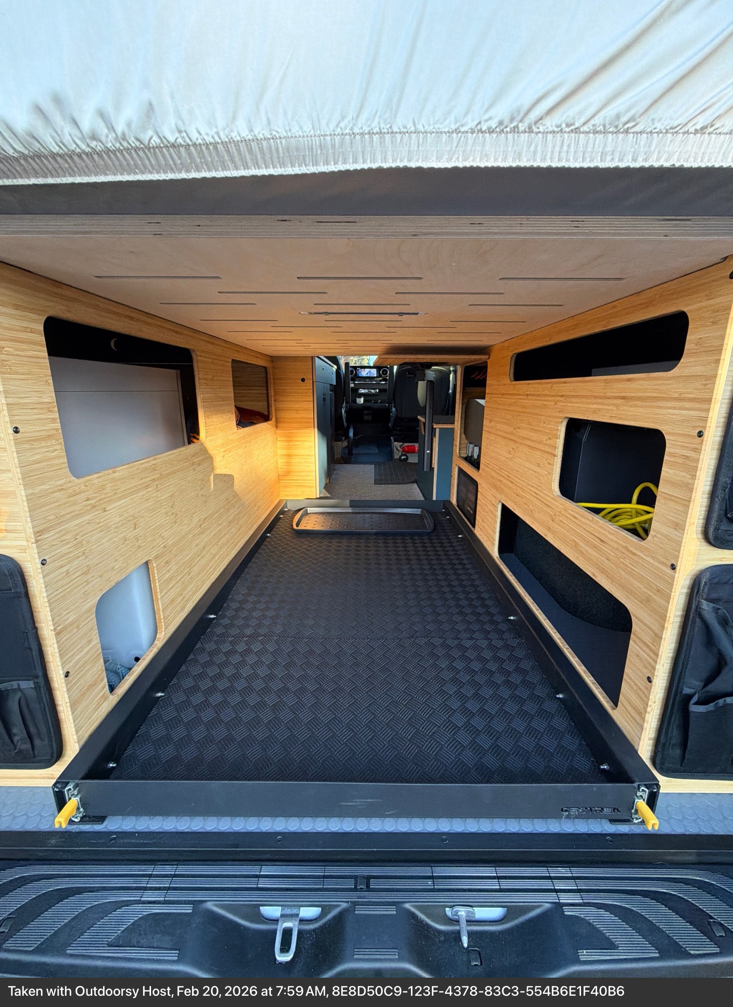 Inside an RV rental van: custom bamboo walls, a versatile pull-out bed platform, and integrated storage. Ready for your trip.. W1Y4NBVY4ST232112 Geotrek 2025