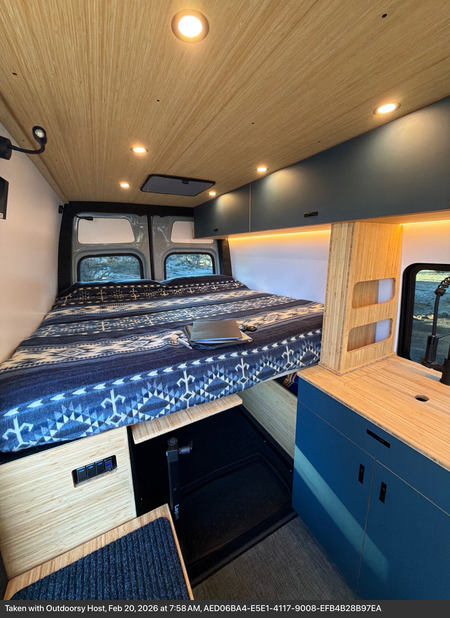 Cozy RV rental interior with bed, kitchen, and warm lighting, perfect for van life adventures and travel.. W1Y4NBVY4ST232112 Geotrek 2025