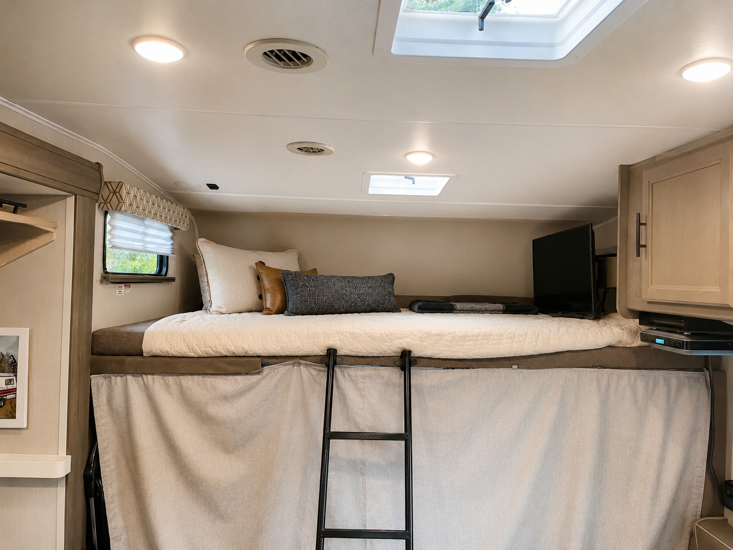 Inside an RV rental: a cozy bunk bed with ladder, window, and TV. Ideal for comfortable journeys.. Coachmen Freelander 26DS 2020