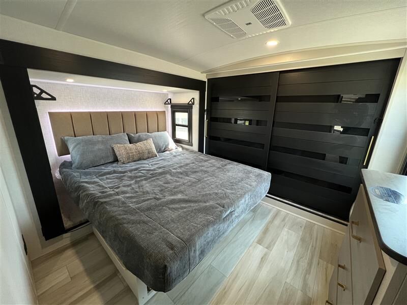 Spacious, modern RV rental bedroom featuring a large bed, elegant dark closet, and contemporary decor for comfortable travel.. Forest River Salem Hemisphere 2025