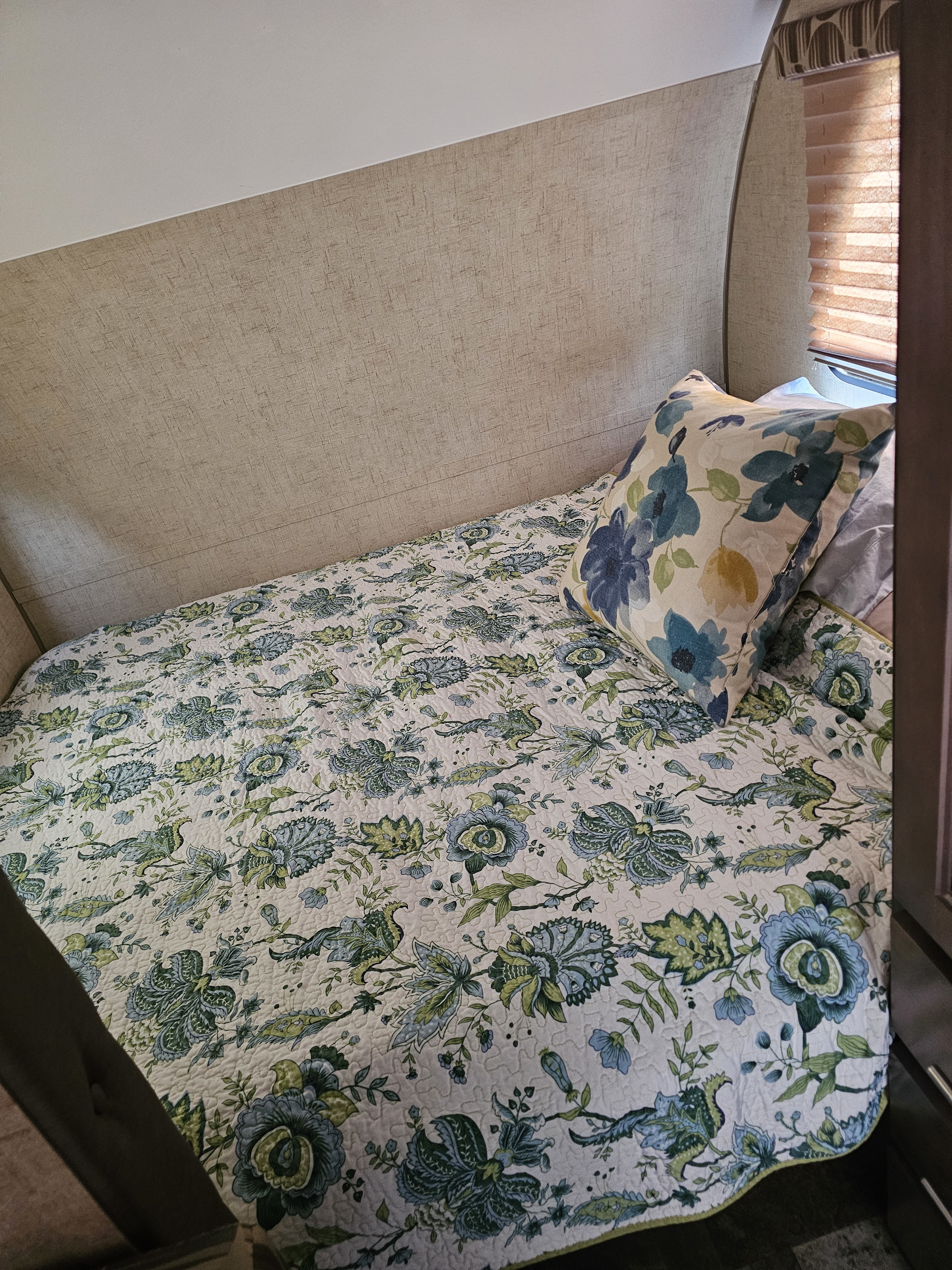 RV rental bedroom: A comfortable bed dressed in a blue and green floral quilt and matching decorative pillow.. R-Pod R-Pod Trailer 2015