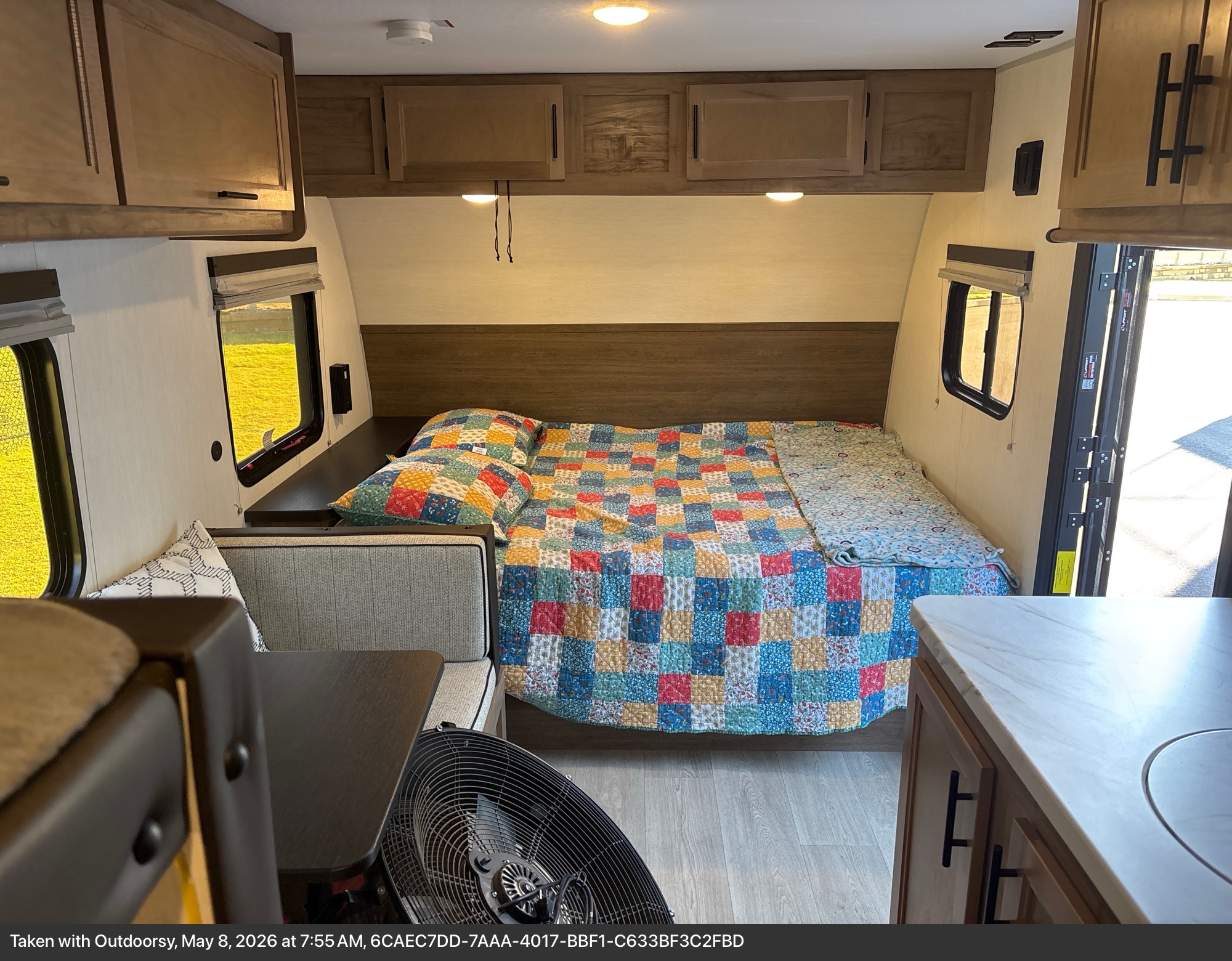 Cozy rv rental interior: colorful bed, dinette, compact kitchen. Bright windows show green. Ideal for travel.. Forest River Cherokee Wolf Pup 2024