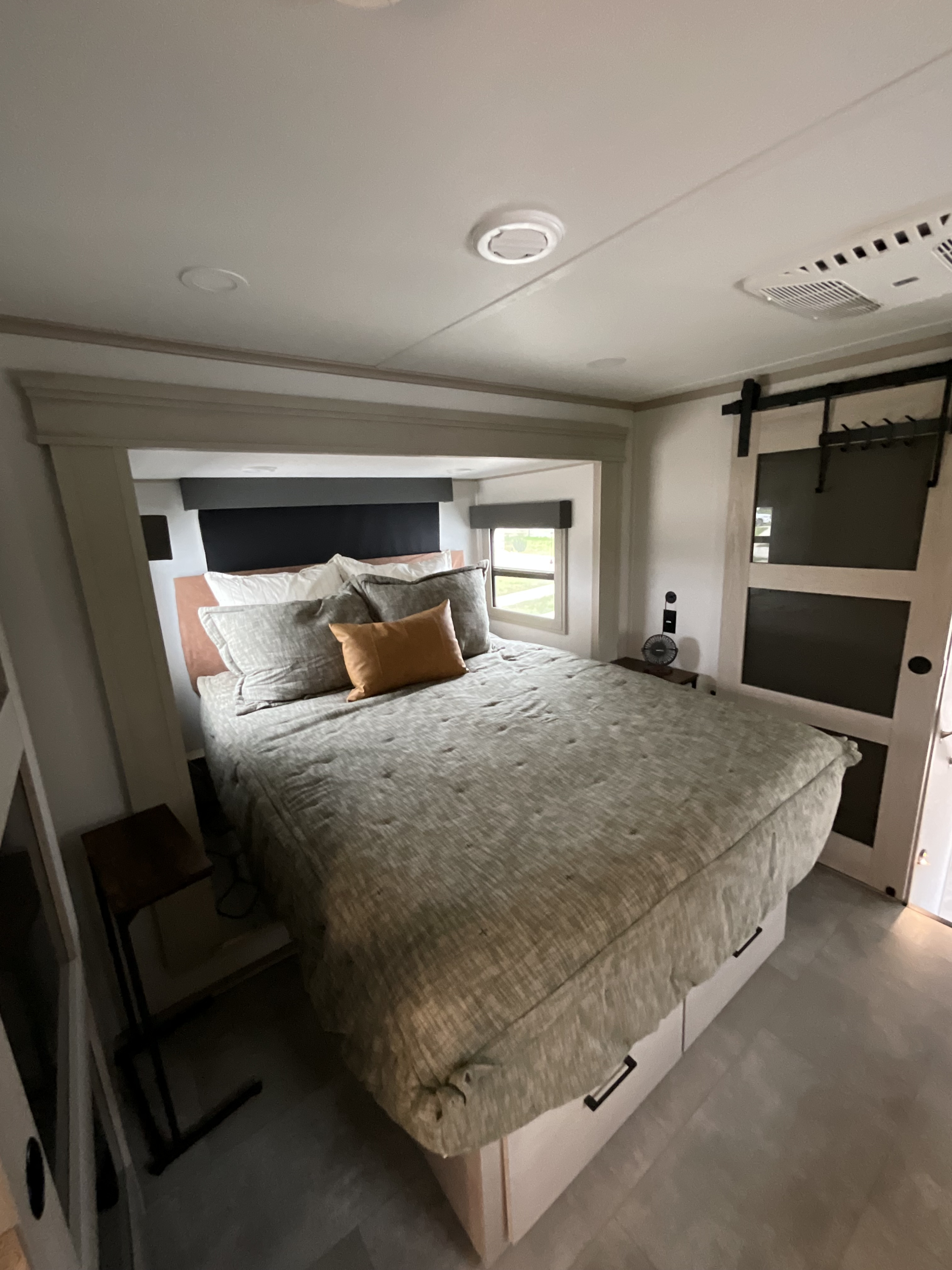 Cozy RV rental bedroom with a comfy bed, integrated storage, and modern touches, great for your next adventure.. Grand Design Solitude 2025