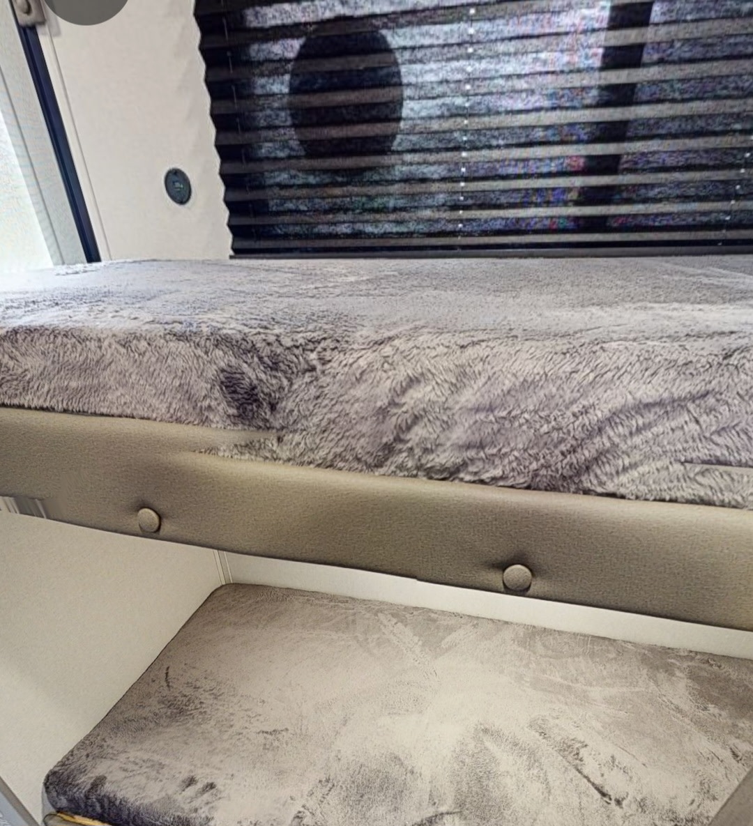 RV rental bunks: fluffy grey top bed, textured lower mattress, window with blinds.. Forest River Coachmen Catalina Summit 2025