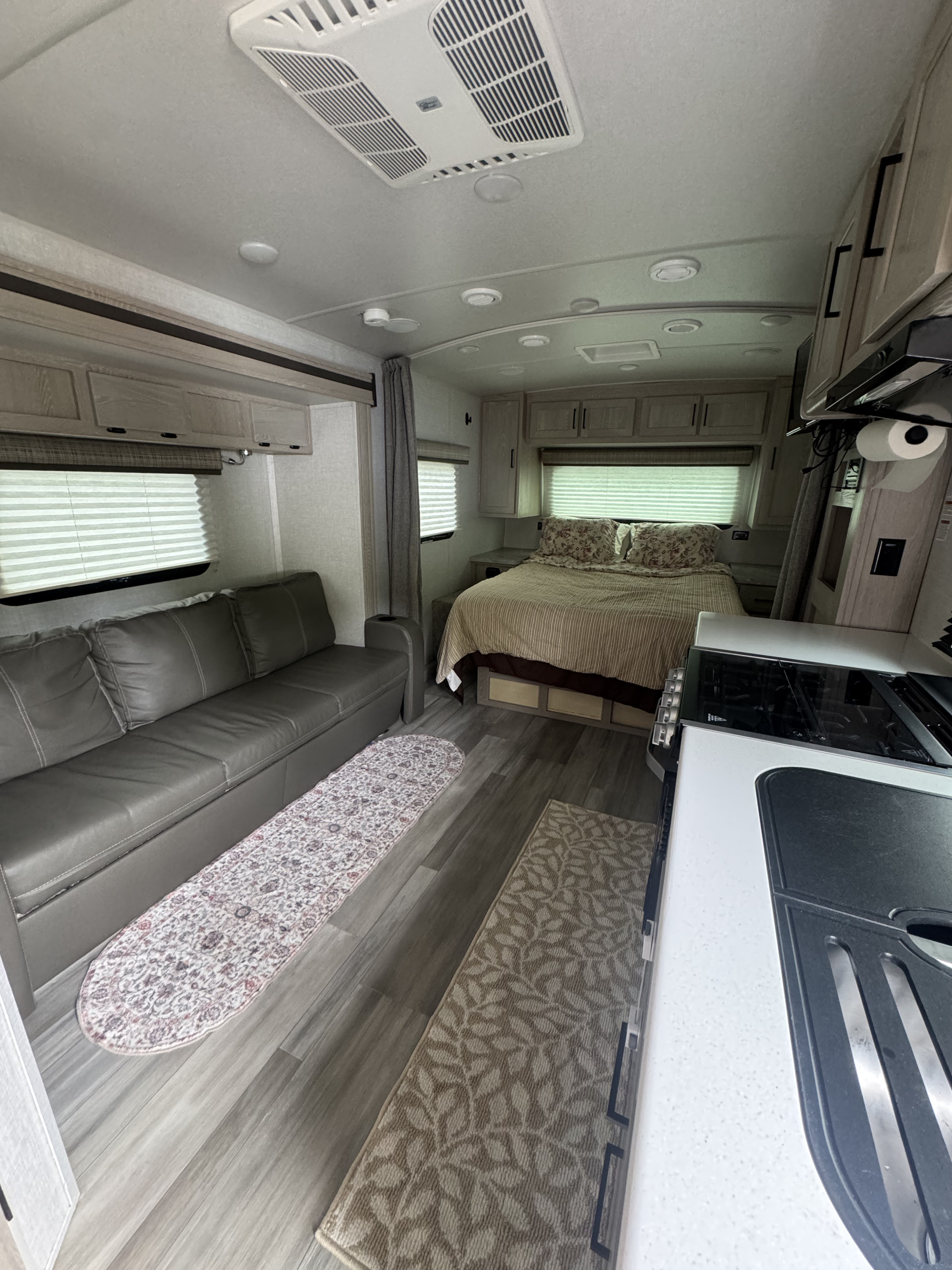 Modern rv rental interior with a comfy living area, cozy bedroom, and compact kitchen setup. Ideal for travel adventures.. Forest River Flagstaff Micro Lite 2021